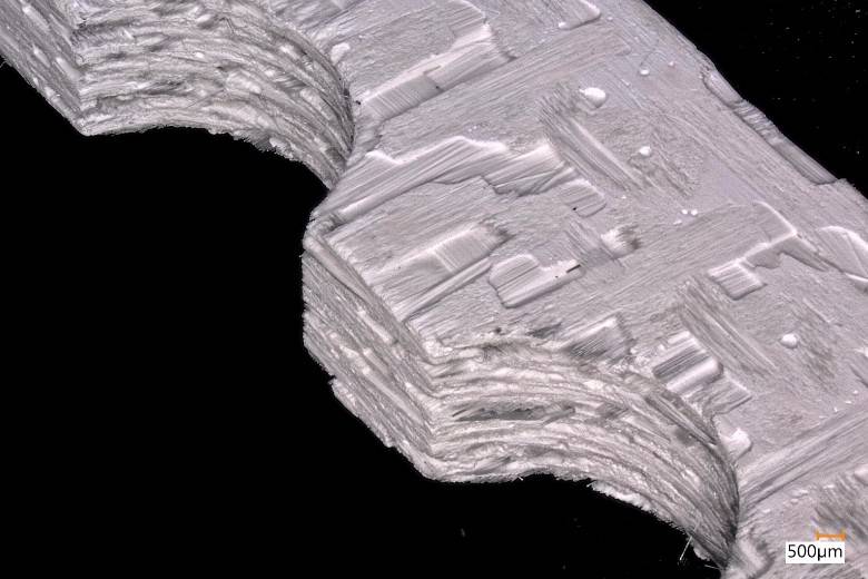 Mikroskopische Aufnahme eines keramischen Verbundwerkstoffs mit zwei Bohrungshälften. 