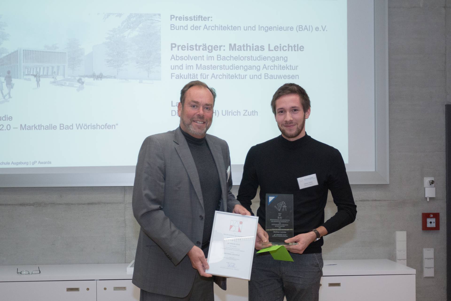 Ulrich Zuth übergibt den Preis des Bundes der Architekten und Ingenieure an Mathias Leichtle.