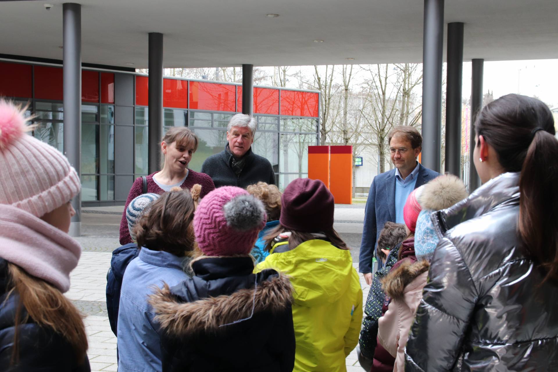 Manuela Mack von der Bibliothek der Hochschule Augsburg begrüßt gemeinsam mit Prof. Dr. Michael Krupp (rechts) die Grundschulkinder.