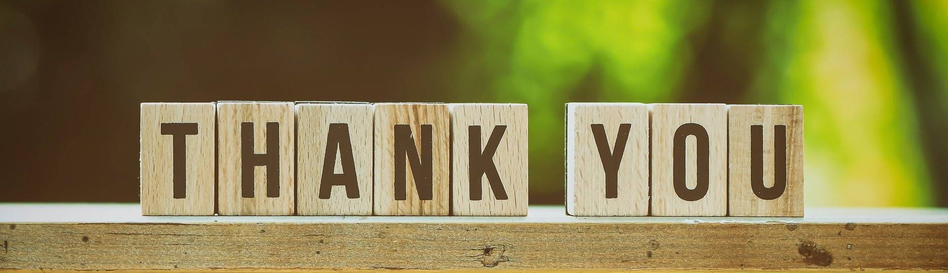 "Thank you" mit einzelnen Buchstaben auf Holzbrett