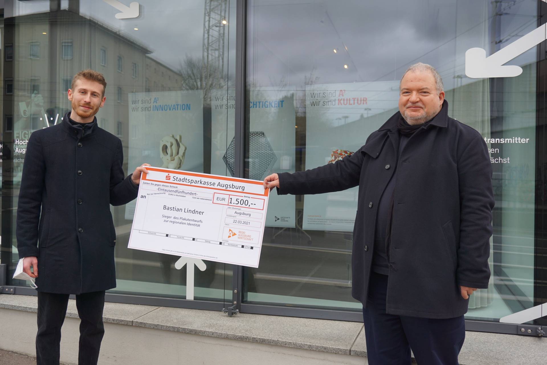 Gewinner Bastian Lindner (links) erhält das Preisgeld von Regio-Geschäftsführer Andreas Thiel © Regio Augsburg Wirtschaft GmbH