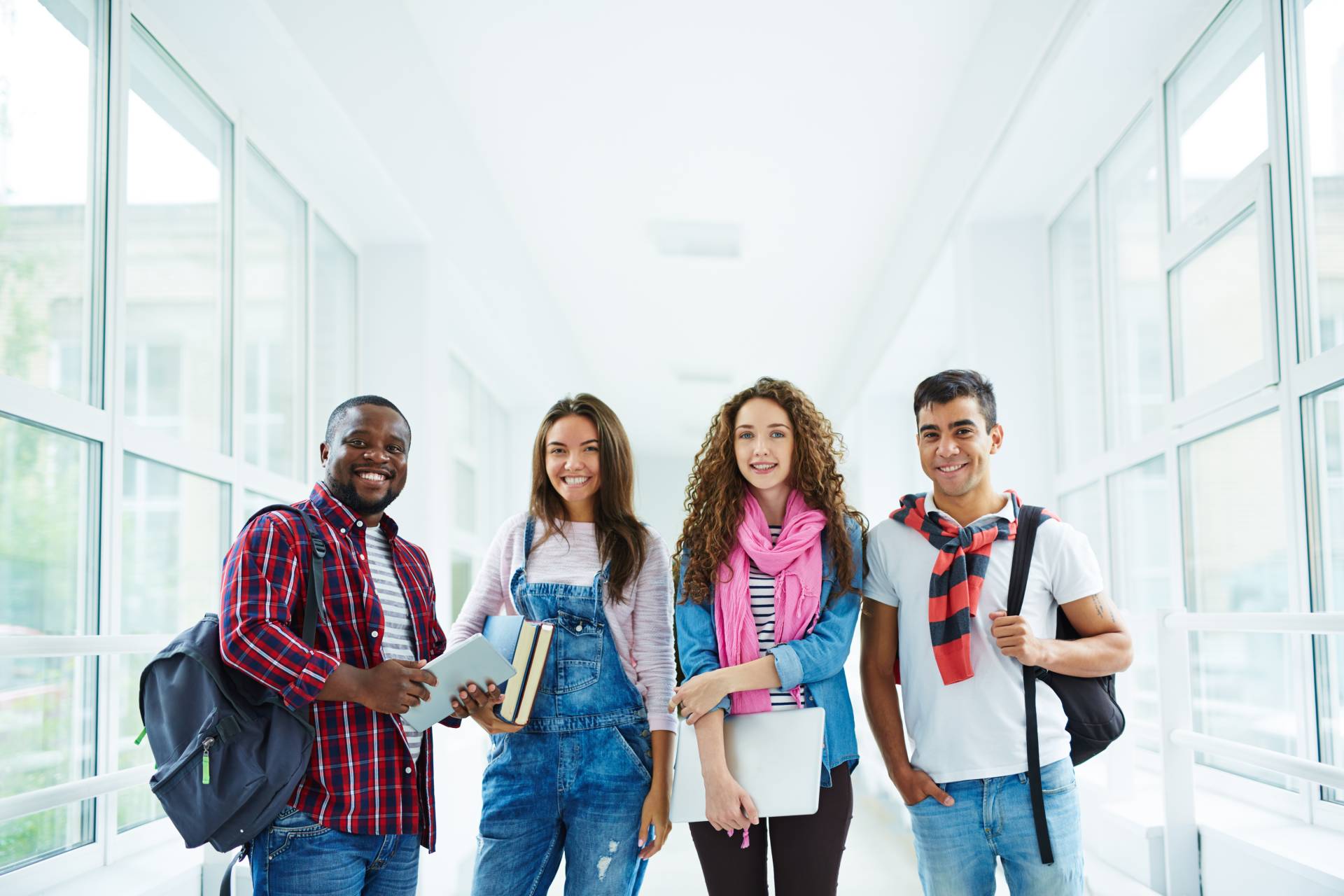 Vier Studierende stehen gut gelaunt in der Hochschule.