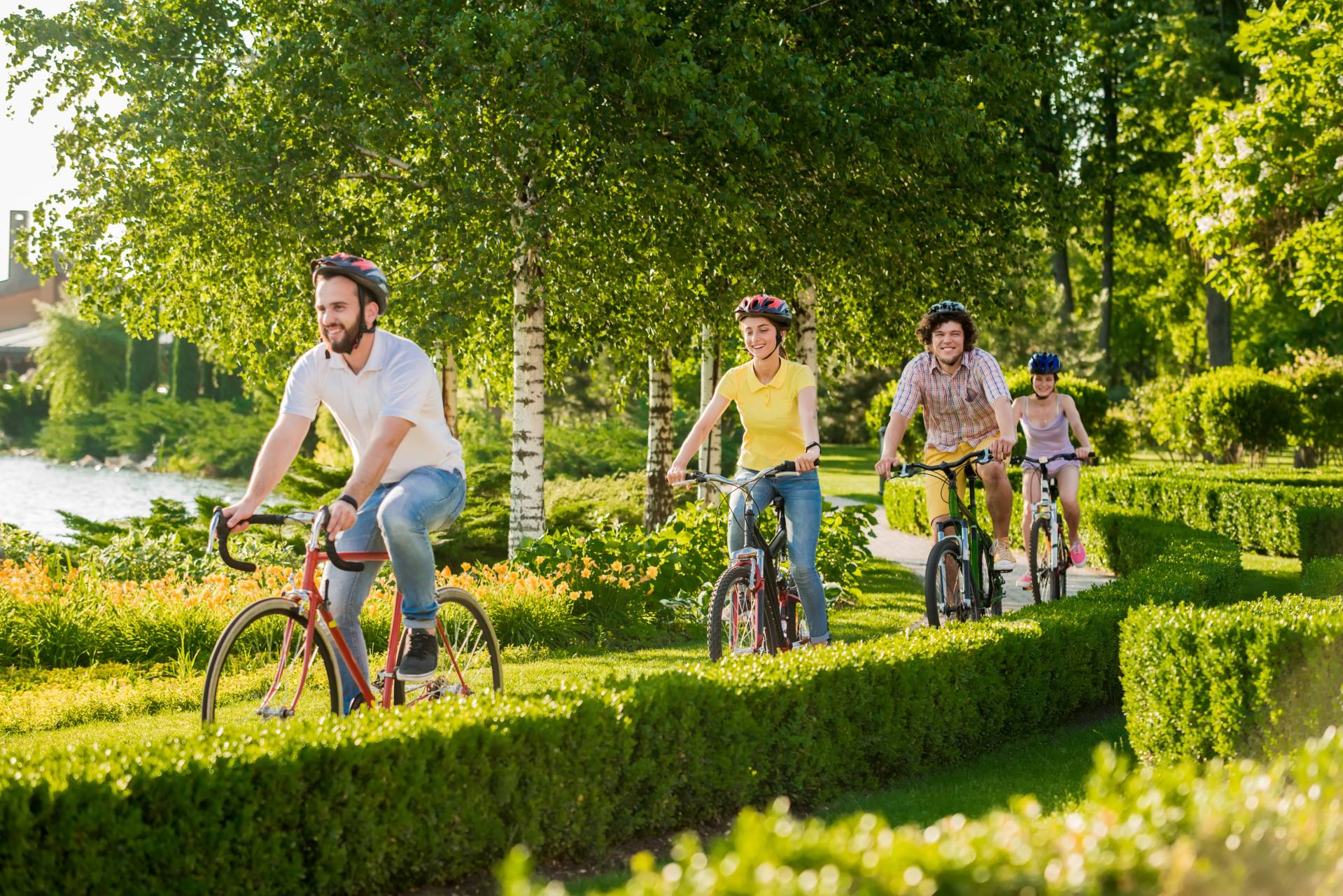 4 Studierende fahren mit dem Fahrrad durch den Park