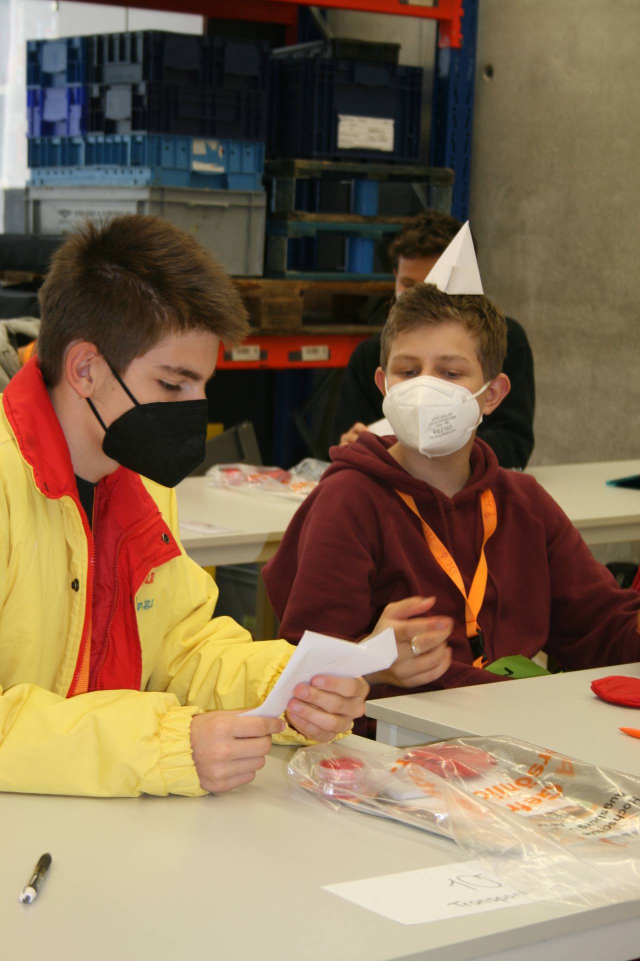 Jungen beim Papierschiffchenbau