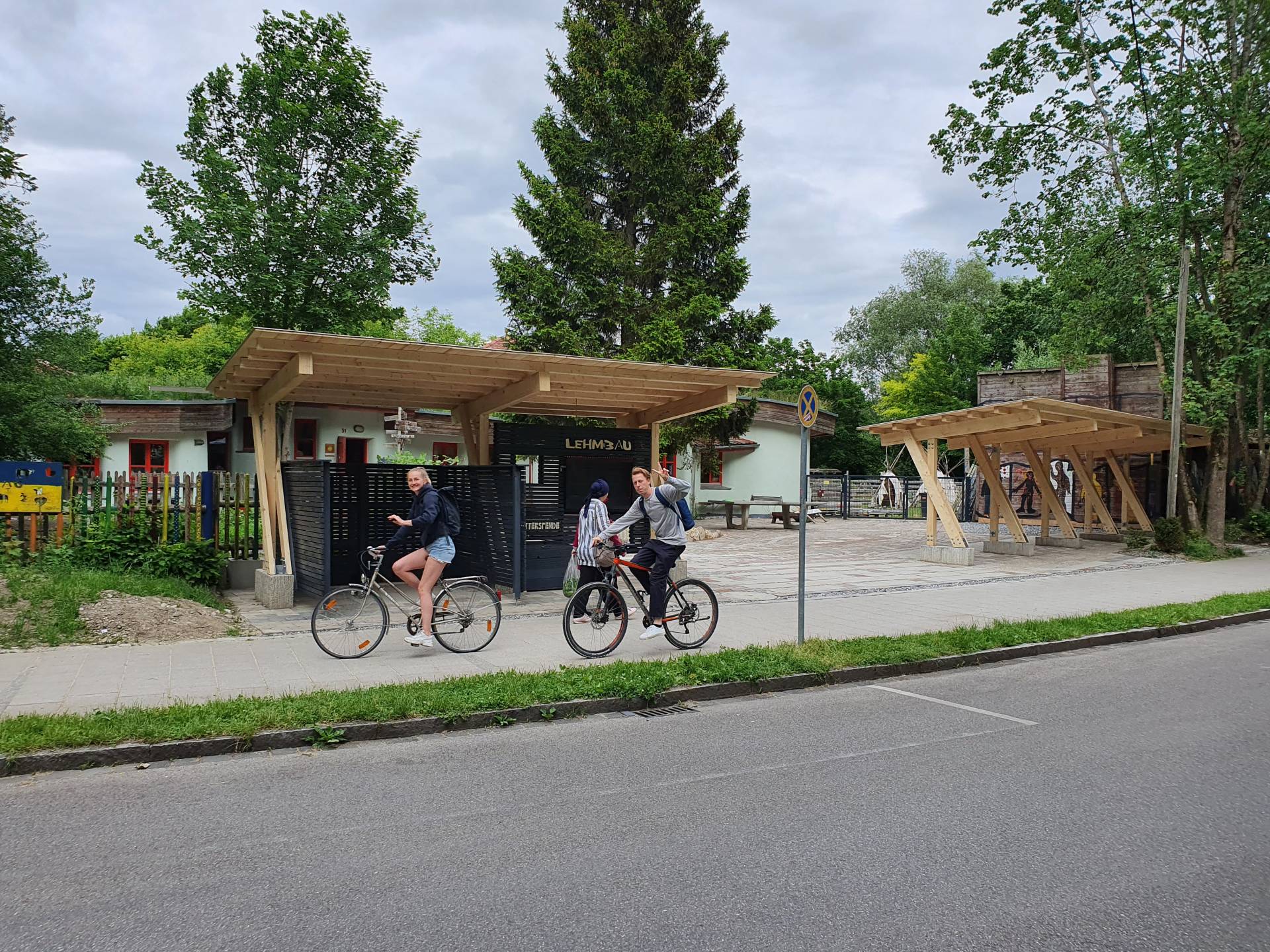 Fahrradfahrende vor dem Lehmbau