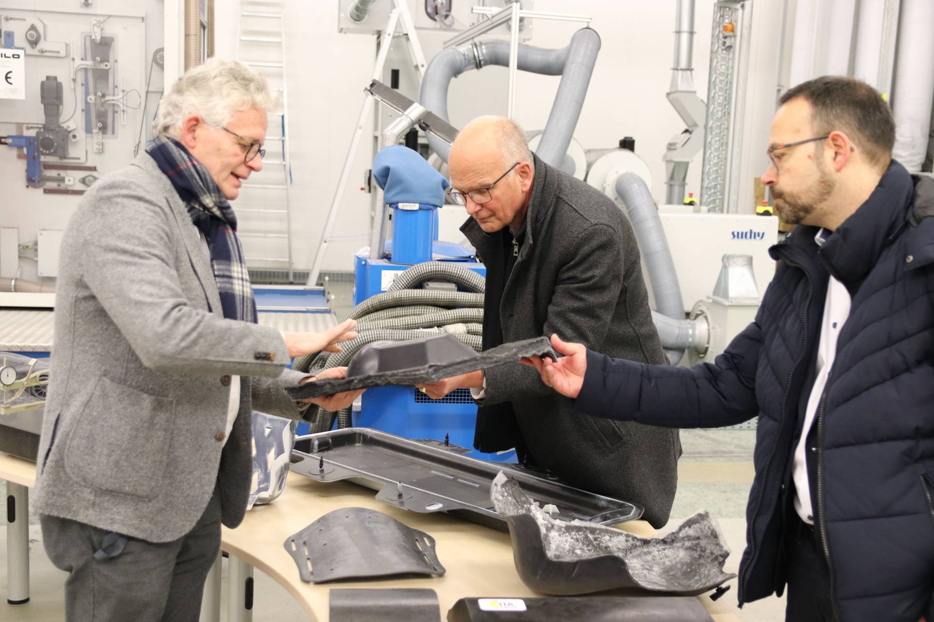 Prof. Schlichter, Dr. Michael Kimke und Prof. Häckel mit Carbonteil.