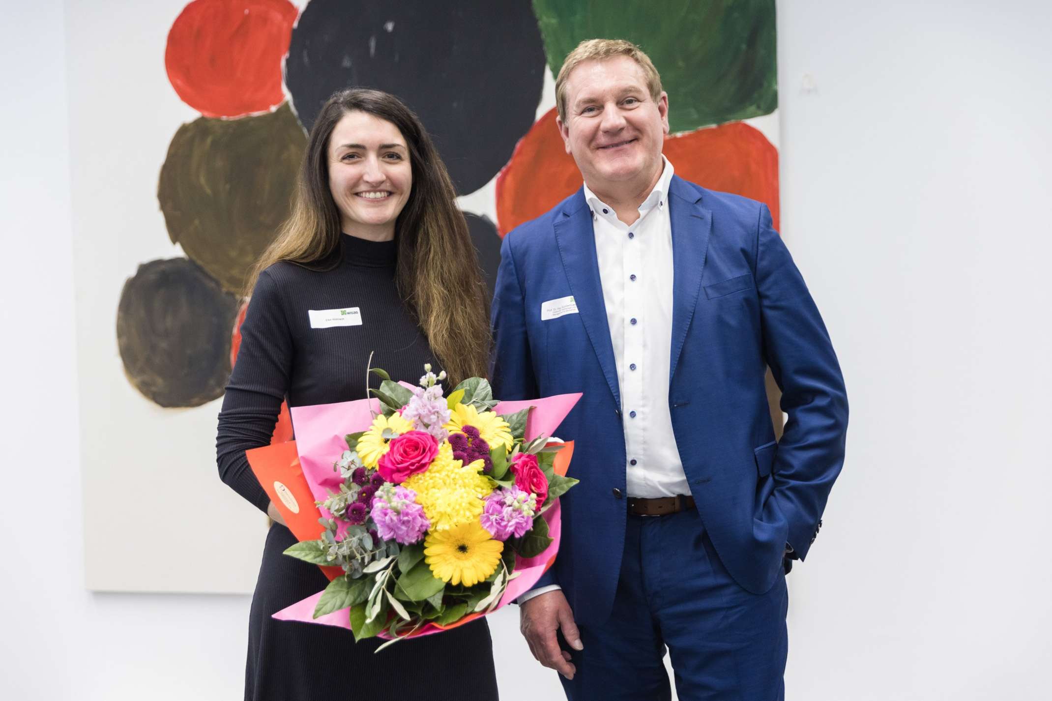 Elke Widmann mit Blumenstrauß und einem der Preisgeber