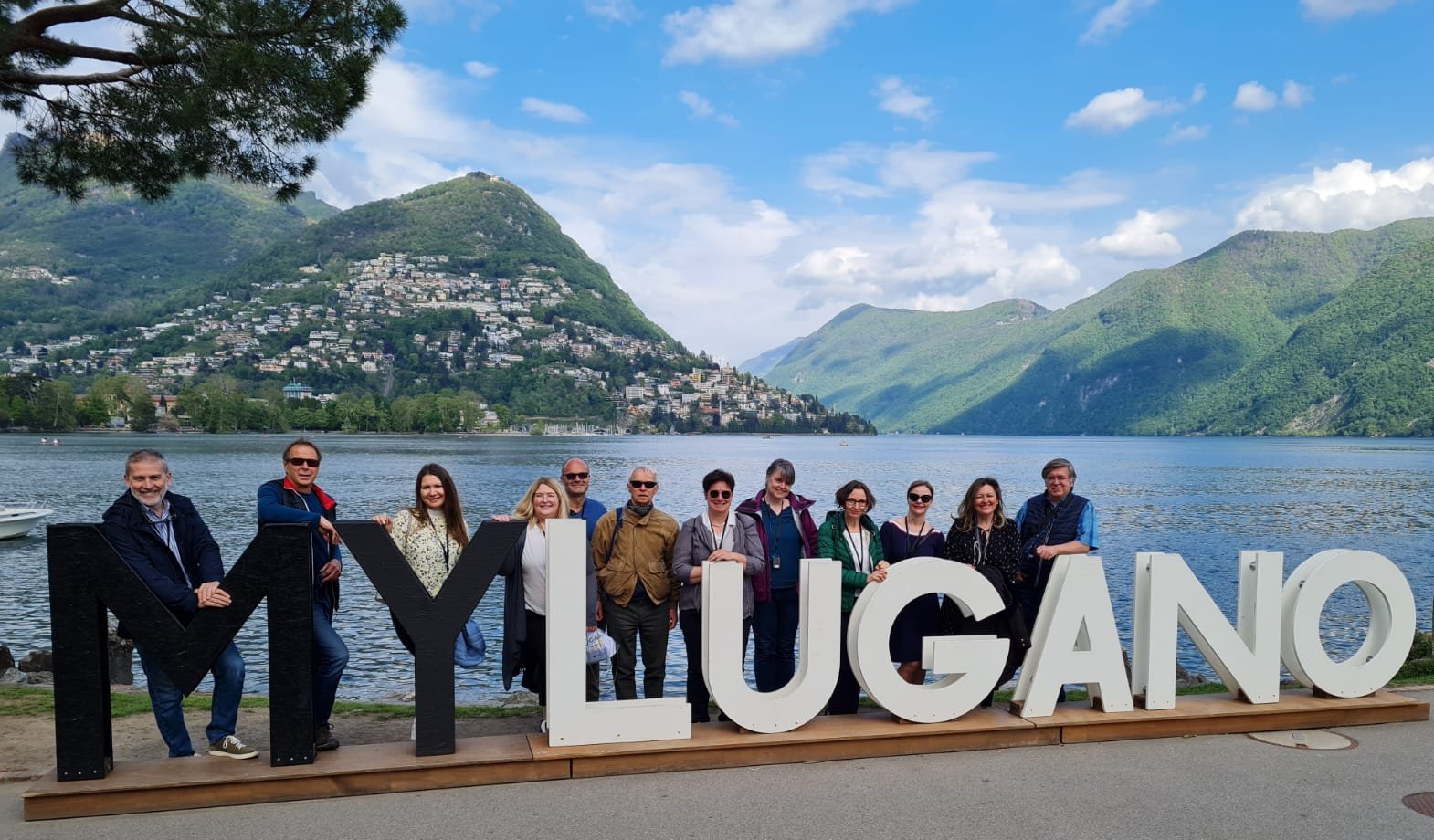 Group picture with the beautiful scenery of Lugano