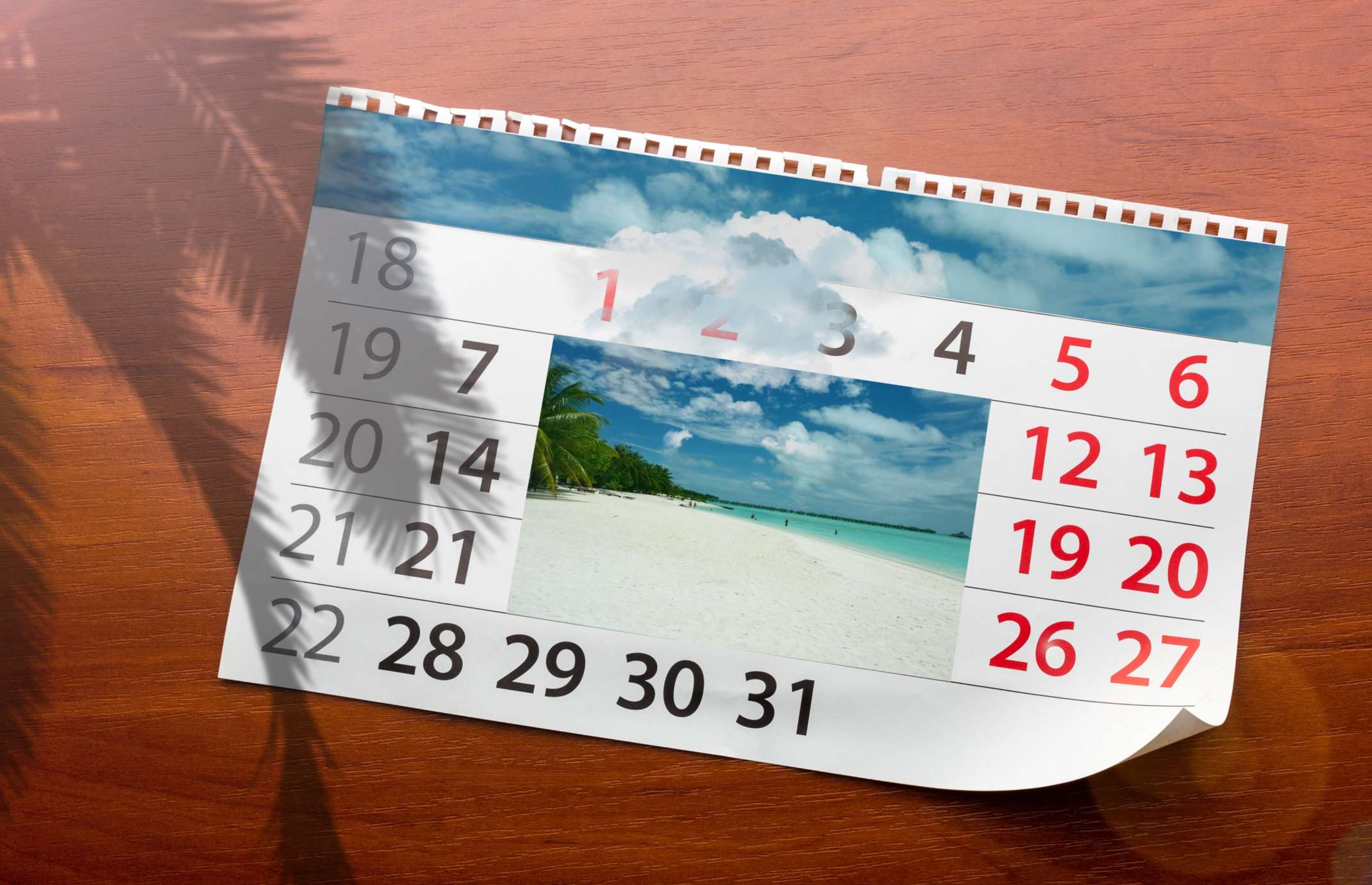 Kalenderblatt auf dem Tisch mit Bild vom Strand