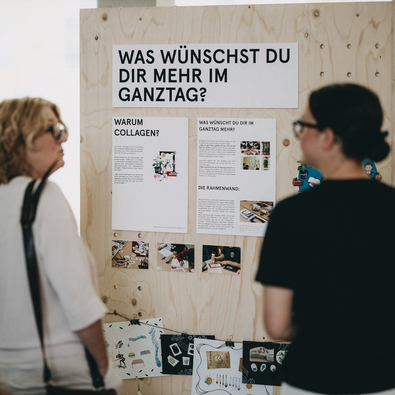 Mehrere Besucher:innen betrachten die Ausstellung &quot;Was braucht der Ganztag&quot;?