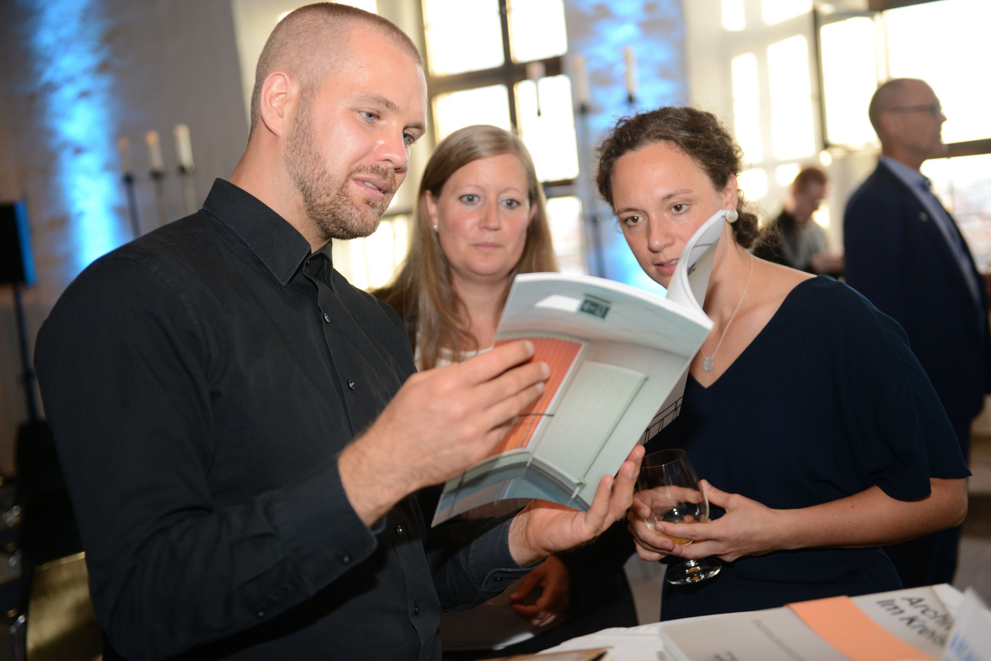 Bayerischer Klimaschutzpreis 2023: Gäste lesen die Publikation "Architektur. Im Kreis."
