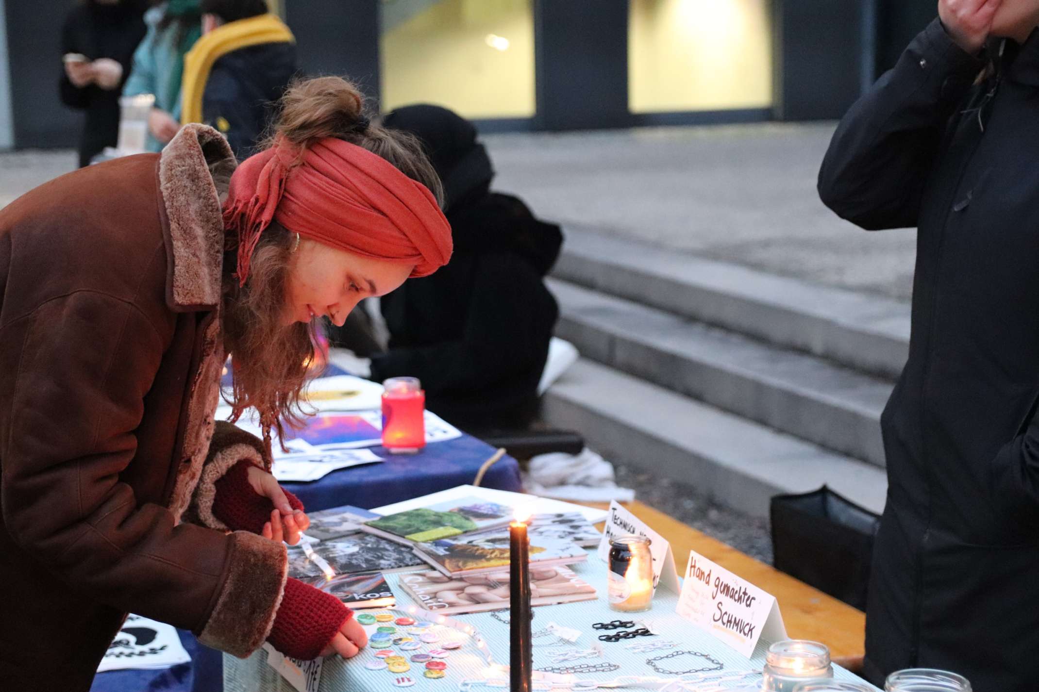 Studentin schaut Kunst an einem Stand an