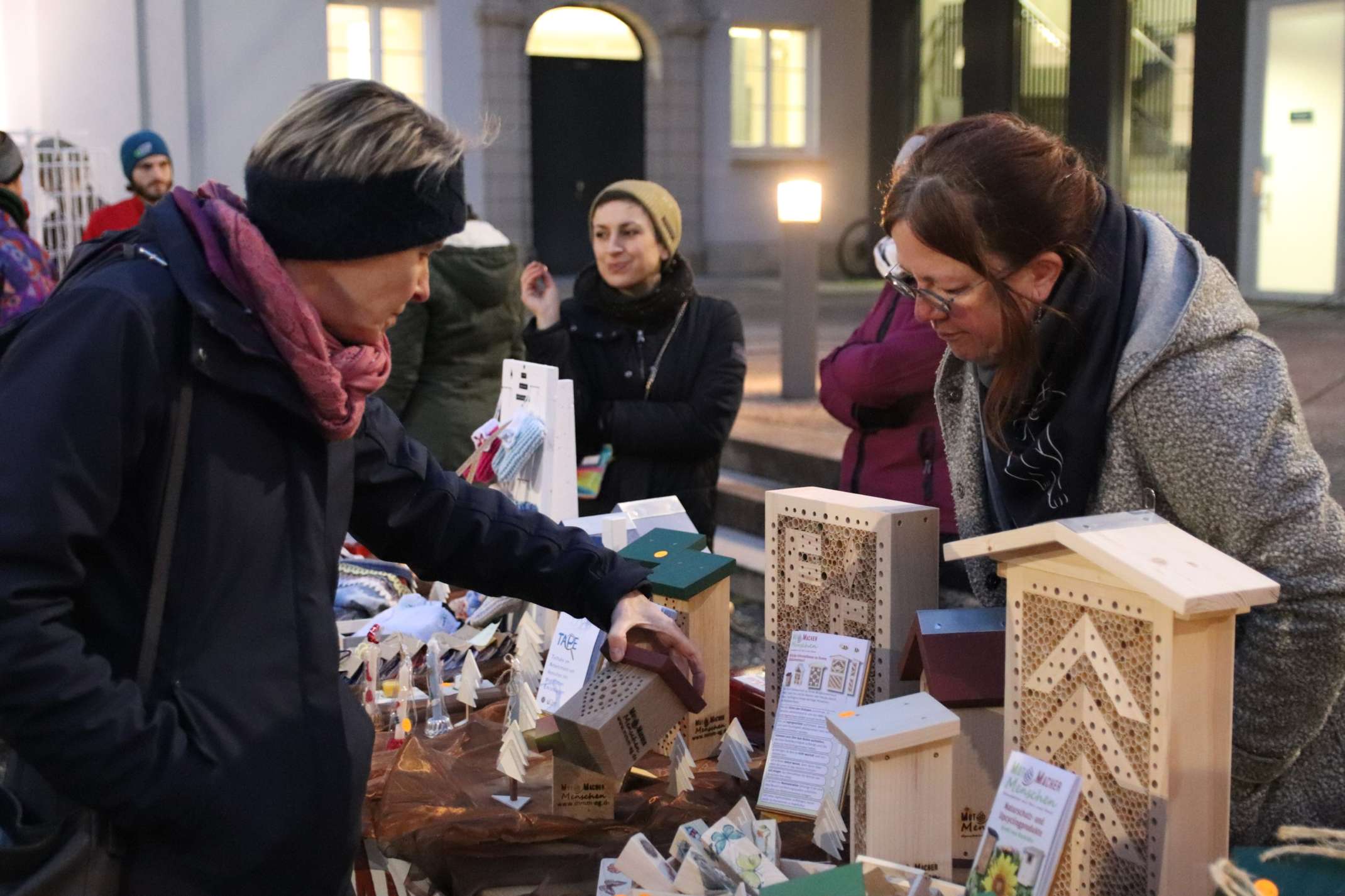 Mitarbeiterin schaut sich Waren an einem Stand an.