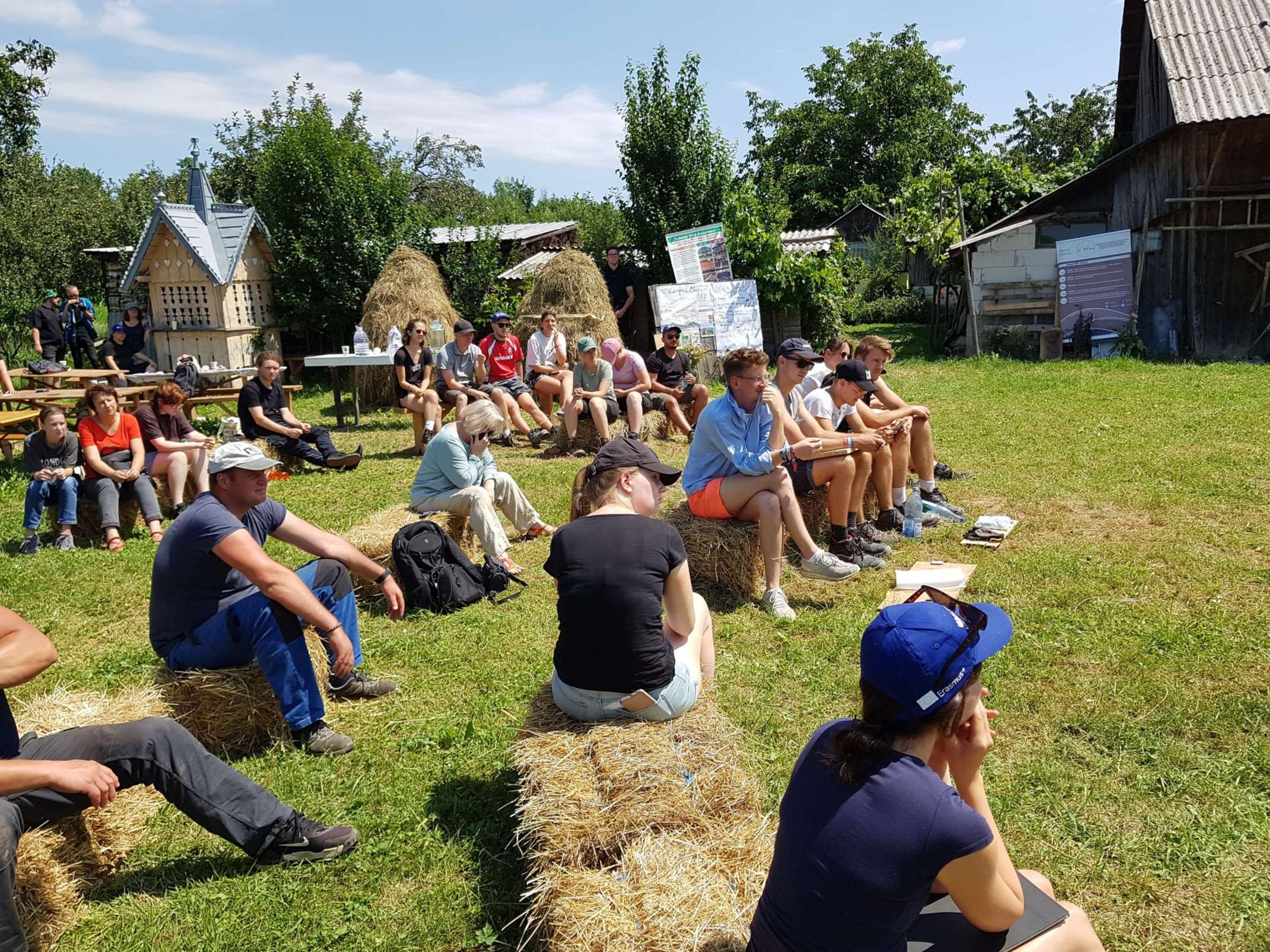 Studierende sitzen auf Strohballen