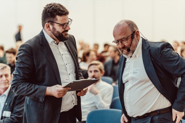 Prof. Wolfgang Huß begrüßt Johannes Kaufmann als Vortragender der Tagung Holzbau 24. Foto: Matthias Leo.