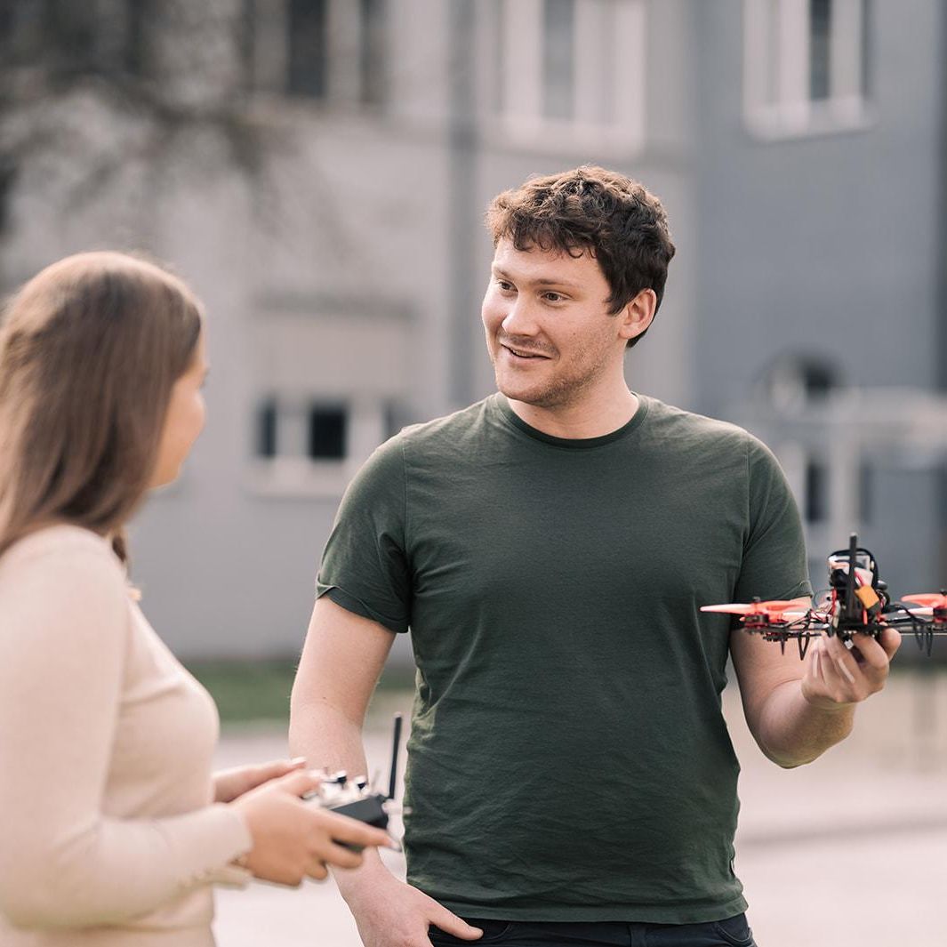 Studierende mit Drohne am Campus am Brunnenlech