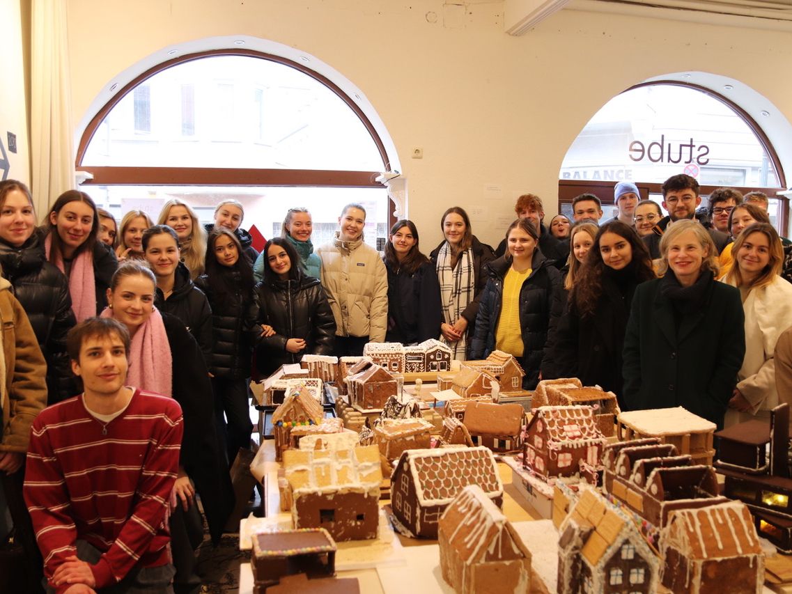 Studierende begutachten Lebkuchenhäuser