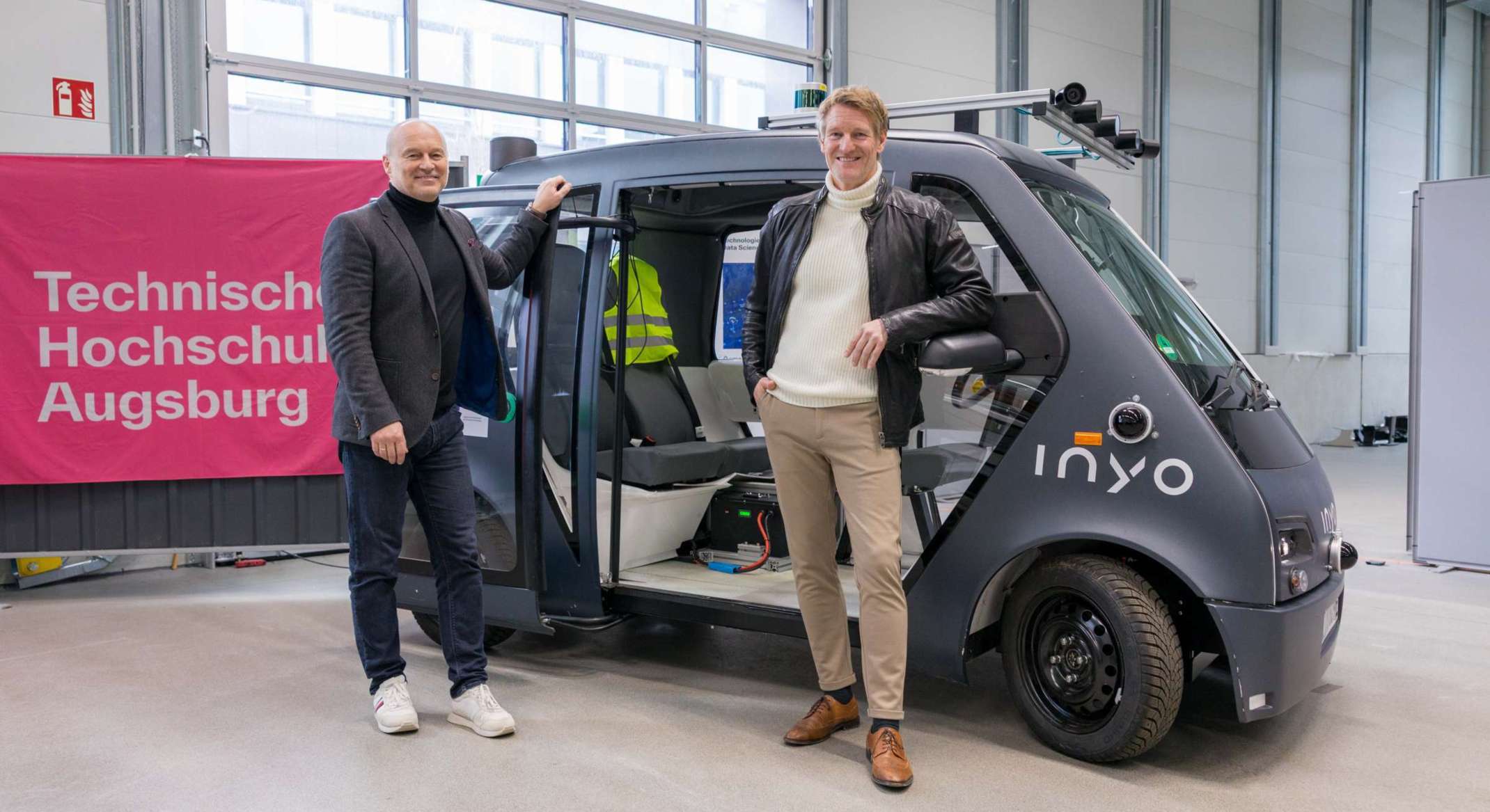 Prof. Dr. Carsten Markgraf und Prof. Dr. Dr. h. c. Gordon Thomas Rohrmair mit dem Forschungsfahrzeug. 