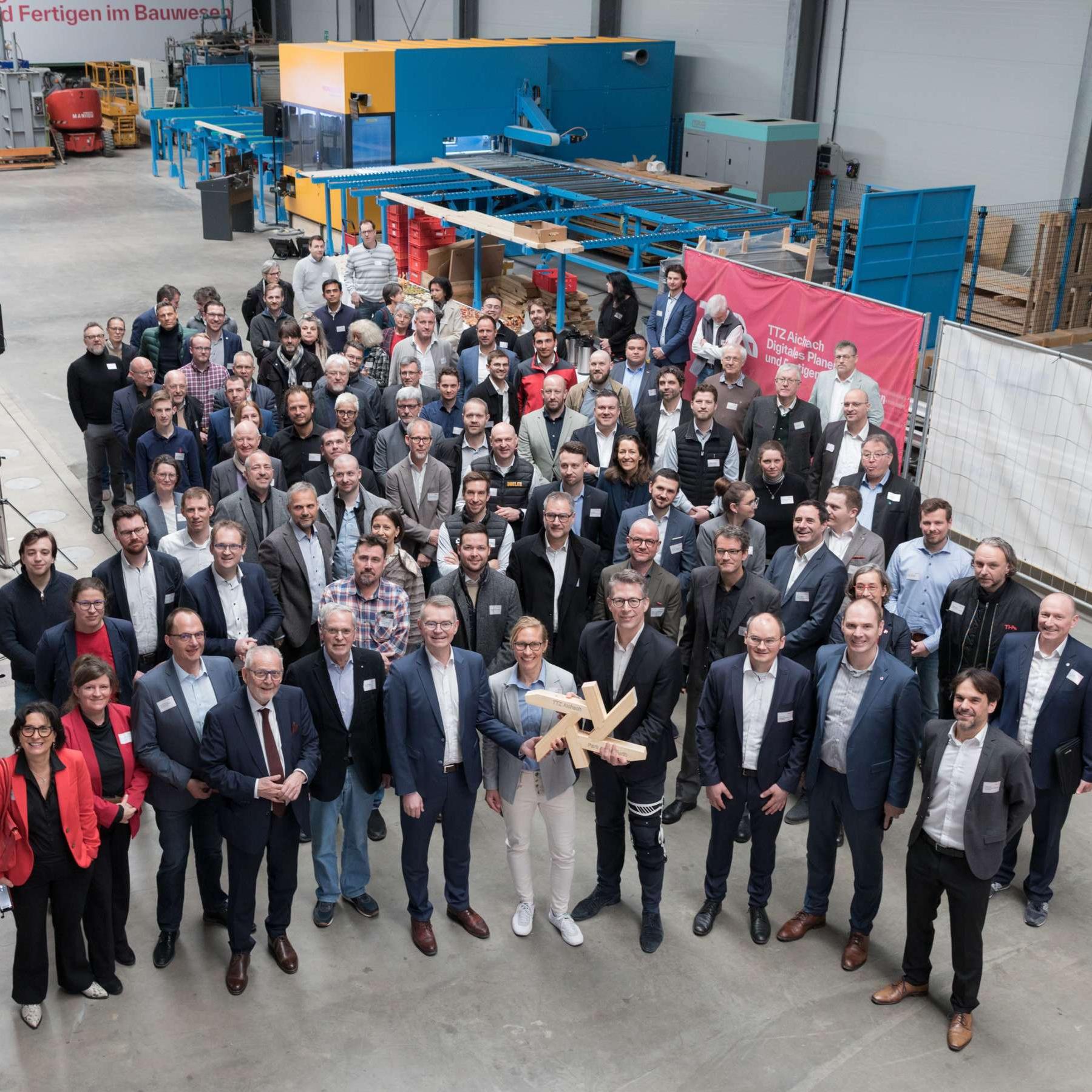 Staatsminister Markus Blume (4.v.l.) eröffnete gemeinsam mit Vertreterinnen und Vertretern aus Politik, Wissenschaft, Wirtschaft und Gesellschaft das TTZ für Digitales Planen und Fertigen im Bauwesen in Aichach. Bild: Matthias Leo/THA. 