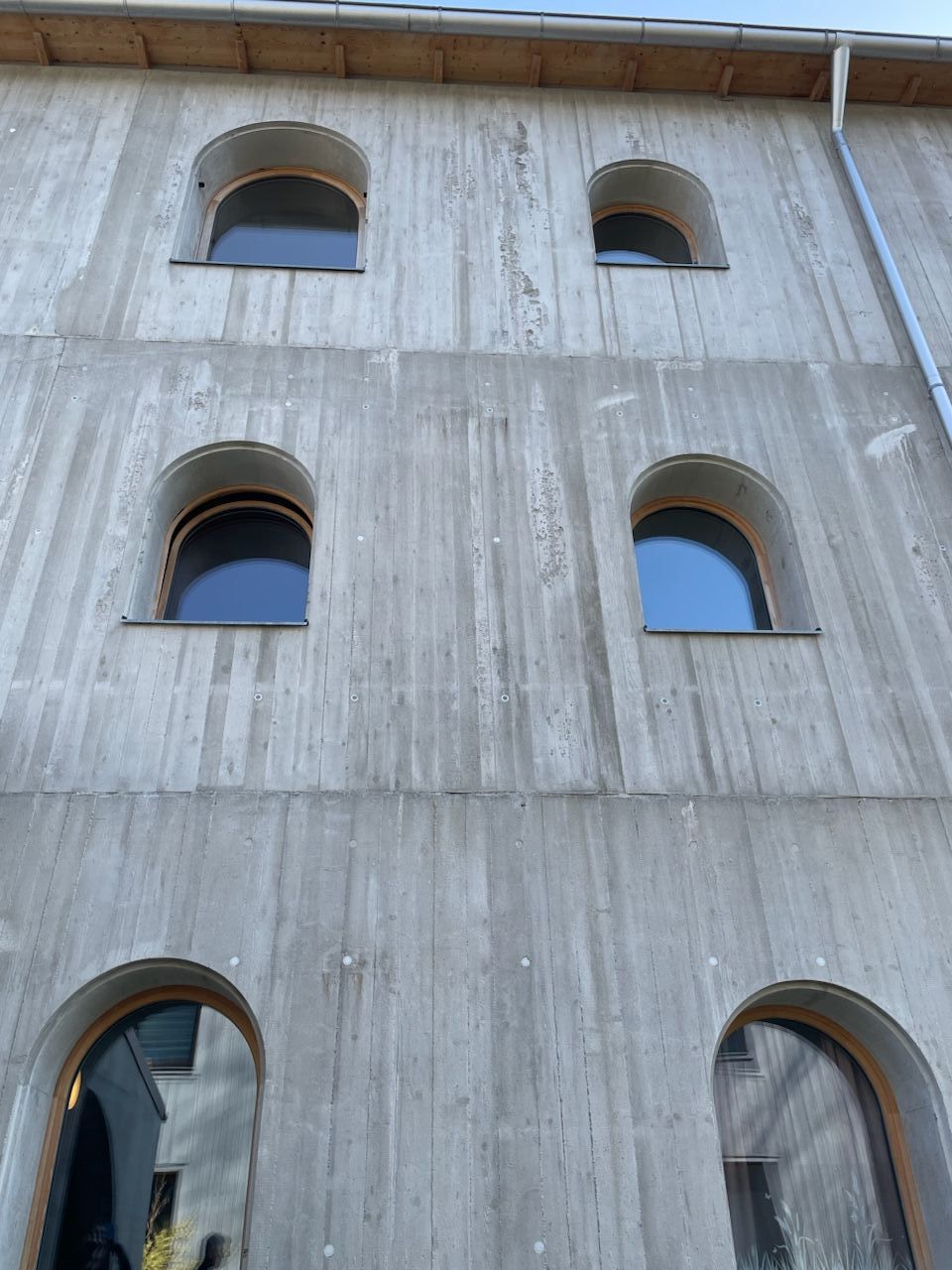 Häuserfront aus Sichtbeton mit Bogenförmigen Fenstern