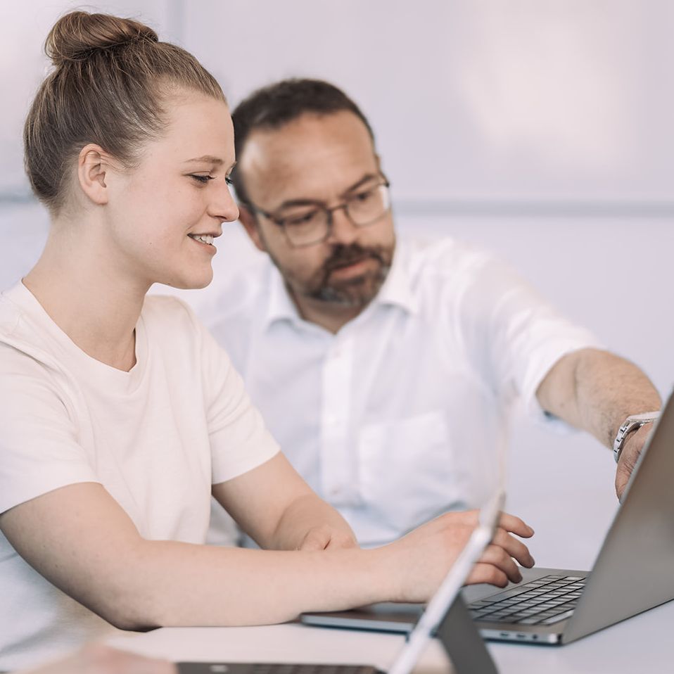 Prof. Dr. Häckel erklärt einer Studentin während einer Vorlesung etwas am Laptop