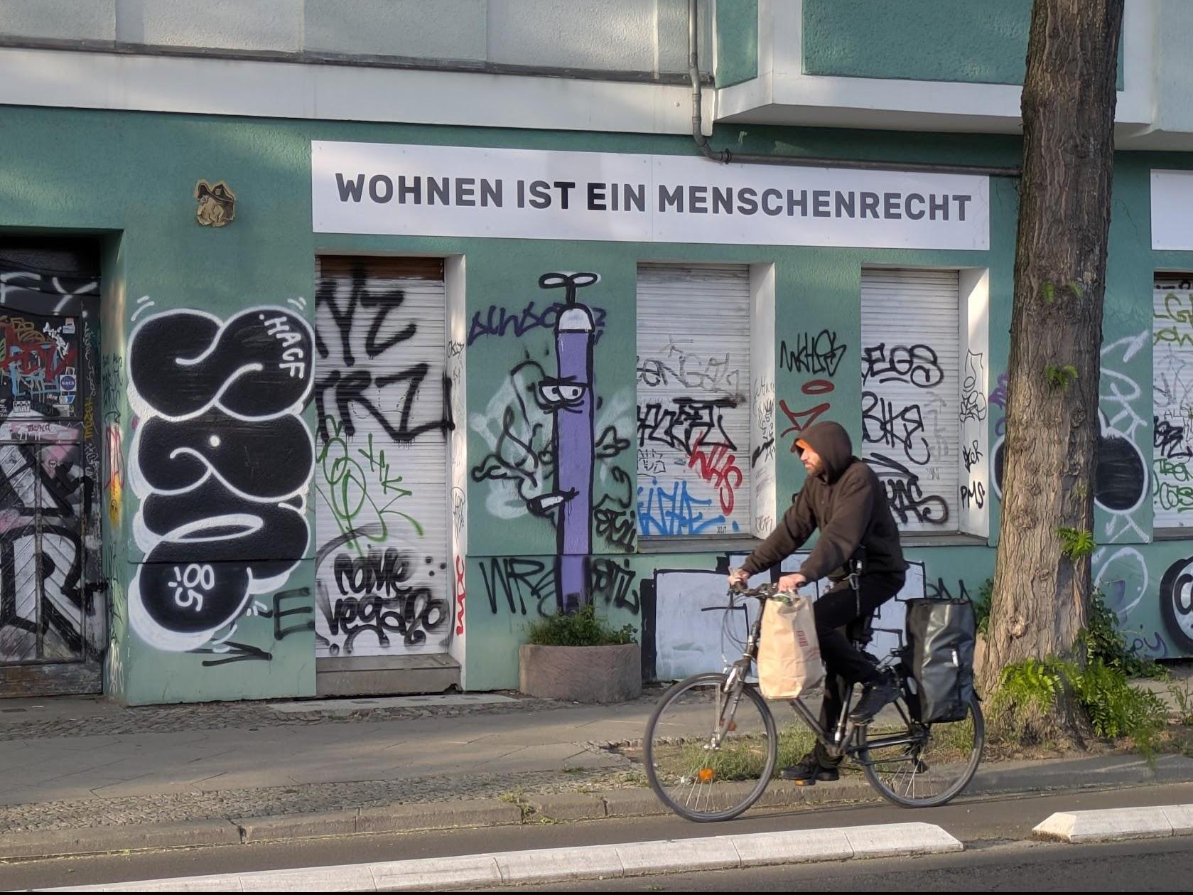 Schild an Fassade: "Wohnen ist ein Menschenrecht" Schild an Fassade: "Wohnen ist ein Menschenrecht"
