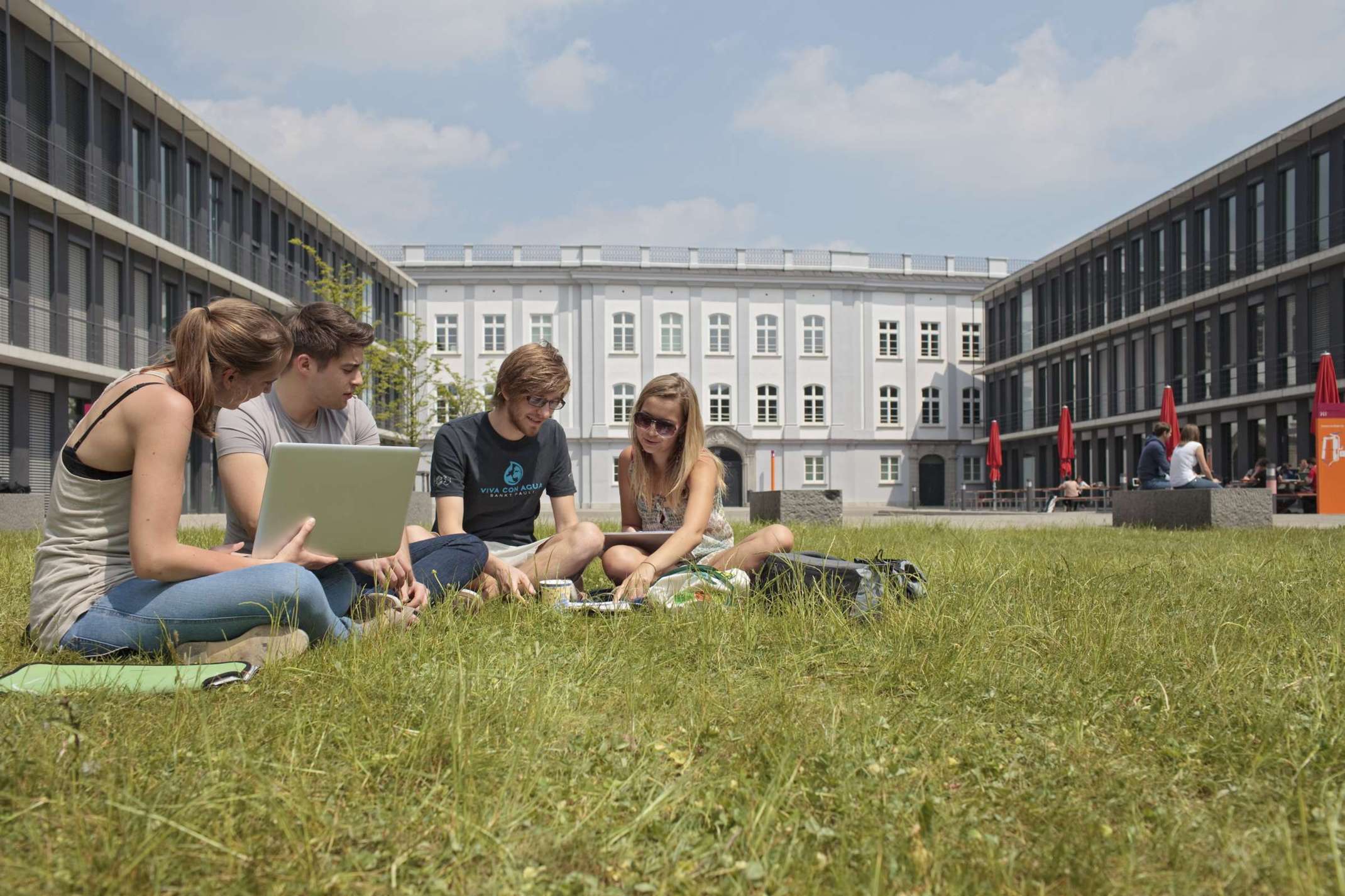 Studierende sitzen mit Laptop in der Campuswiese der THA Studierende sitzen mit Laptop in der Campuswiese der THA