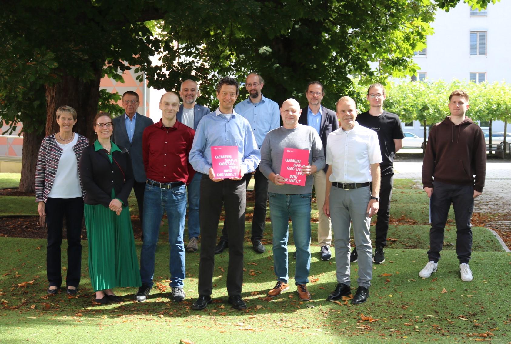Gemeinsames Foto von allen Teilnehmenden nach der Besprechung auf der Wellenwiese im Innenhof der THA. Gemeinsames Foto von allen Teilnehmenden nach der Besprechung auf der Wellenwiese im Innenhof der THA.
