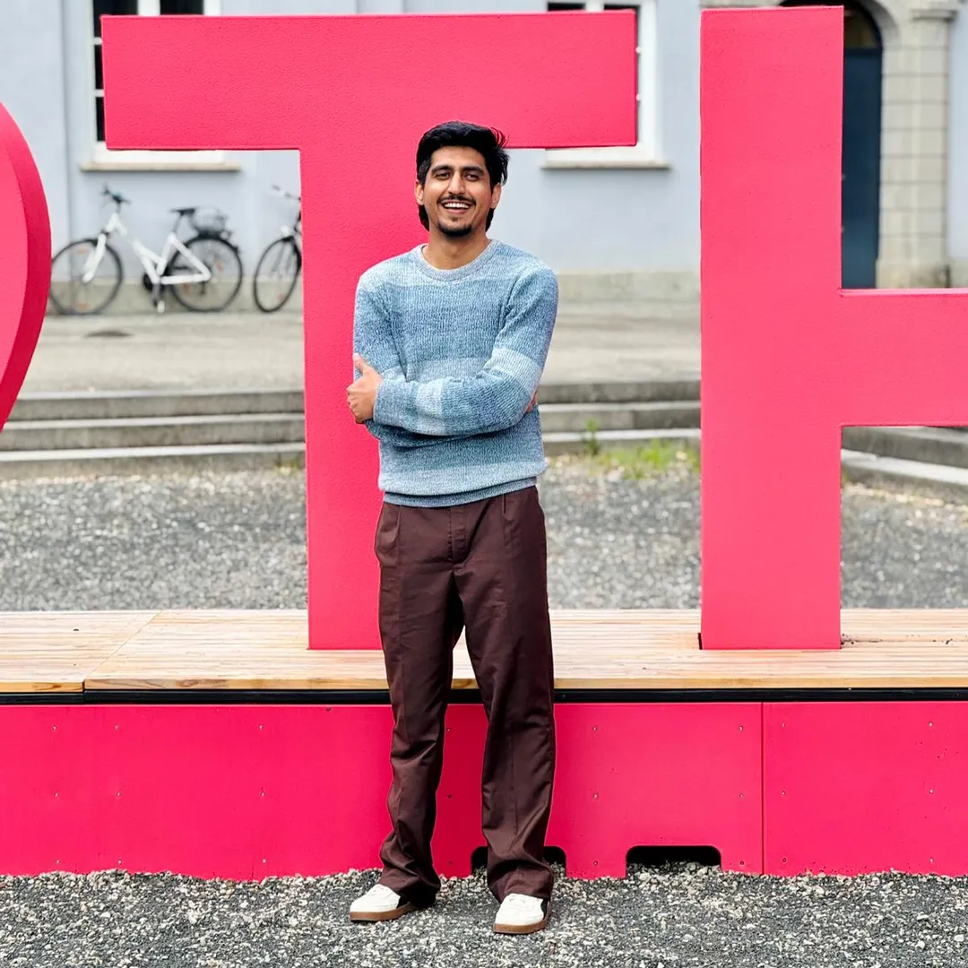 Muhammed Zubair vor dem THA_Logo