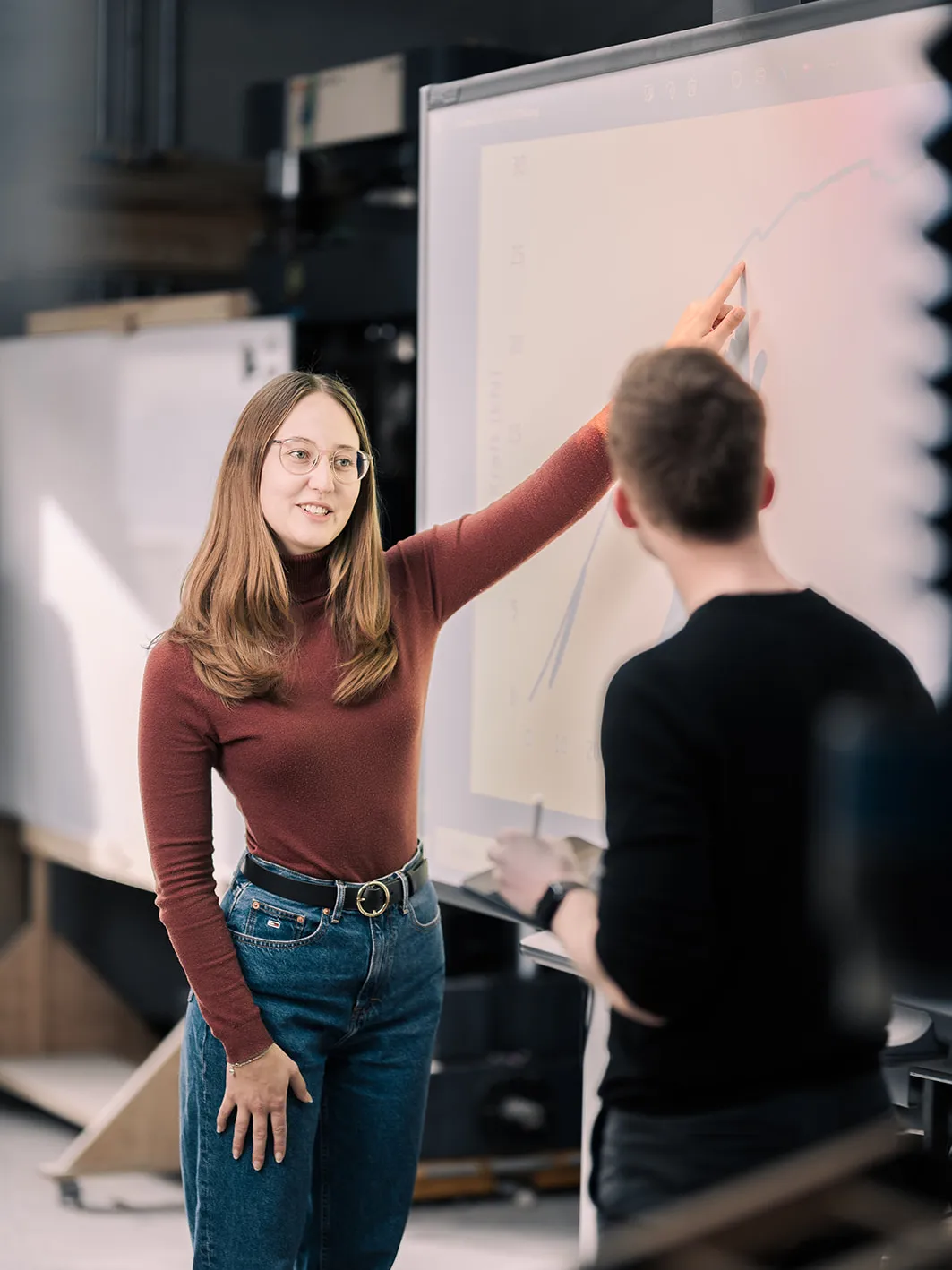 Studentin erklärt ihrem Kommillitonen einen Graph
