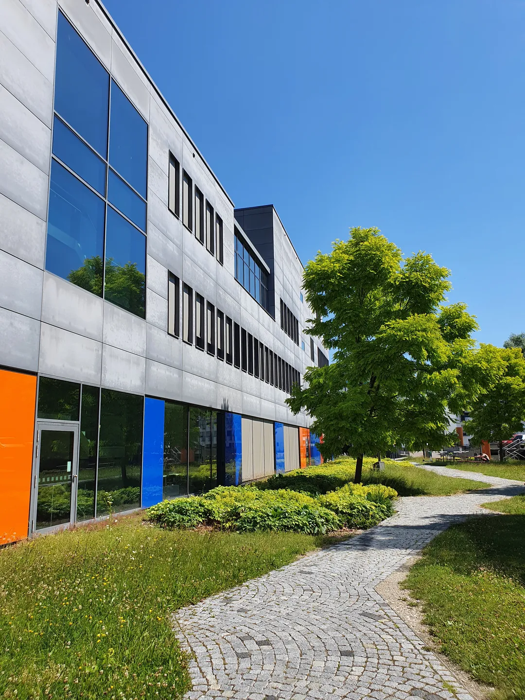 Außenansicht der School of Business vomDurchgang zwischen Gebäude und Parkdeck.