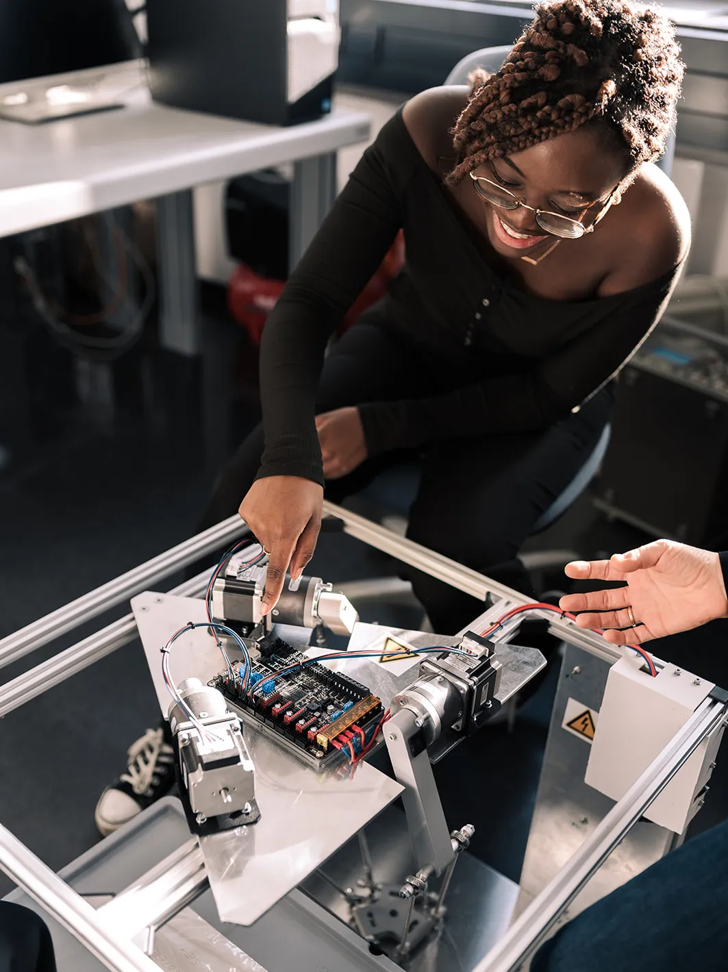 Studierende an einem Mainboard einer Maschine.
