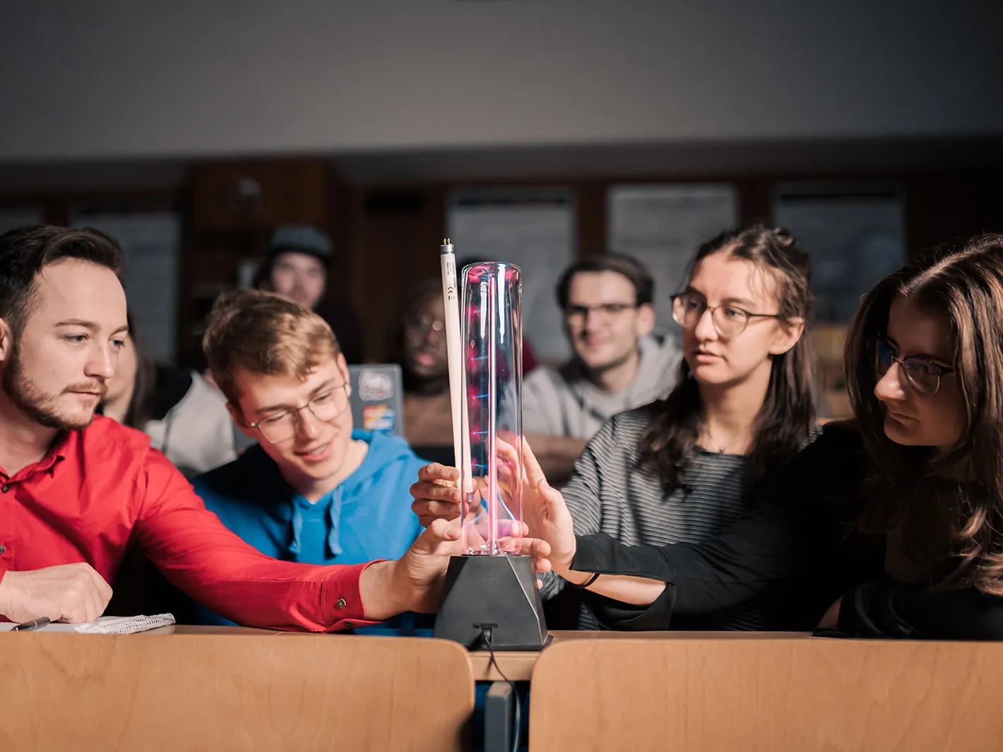 Studierende betrachten Plasmalampe.