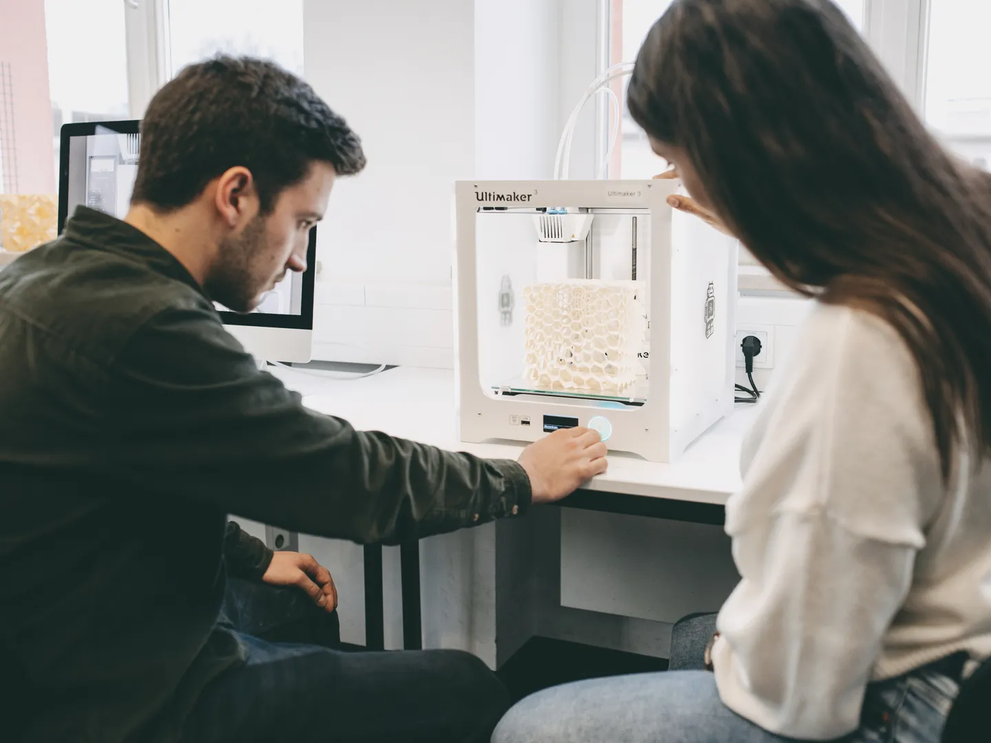 Studierende betrachten 3D-Drucker