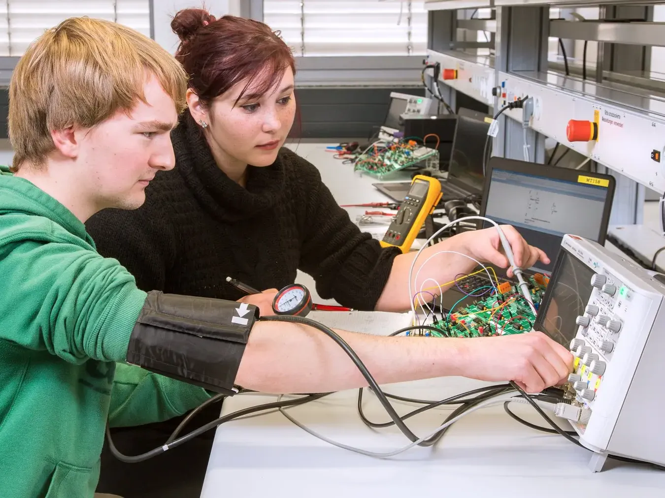 Studierende im Messtechnik Praktikum. Versuch zum Blutdruck messen.