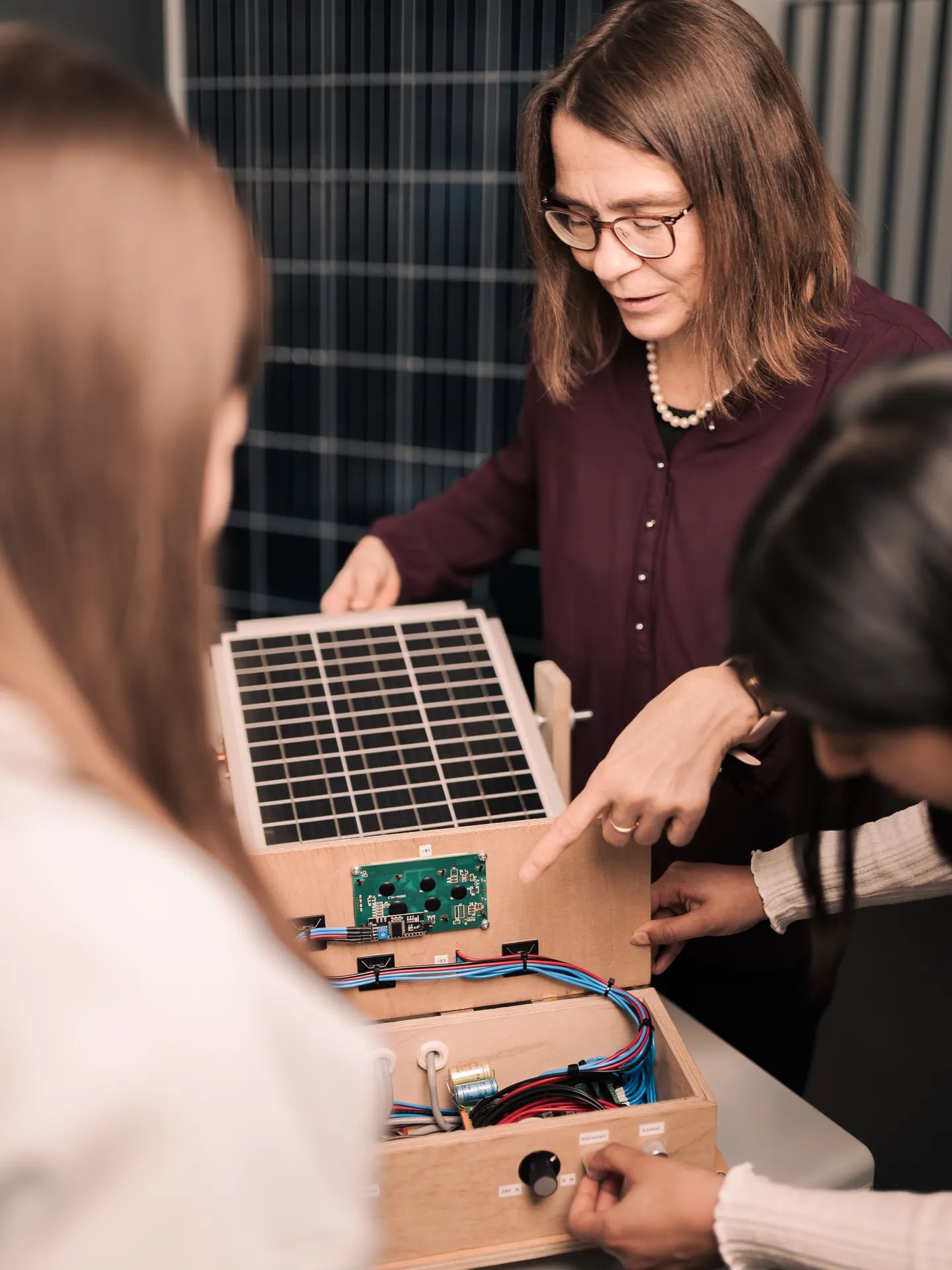Professorin und Studierende an Versuchsaufbau zur Photovoltaik