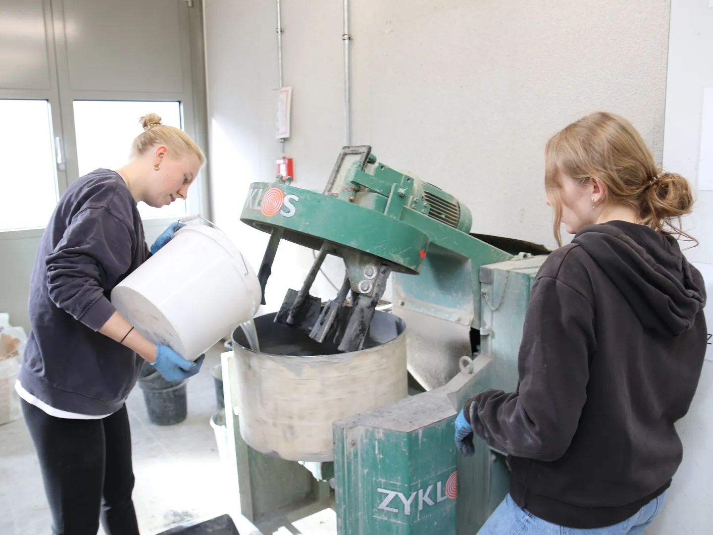 Studentin mischt Beton an