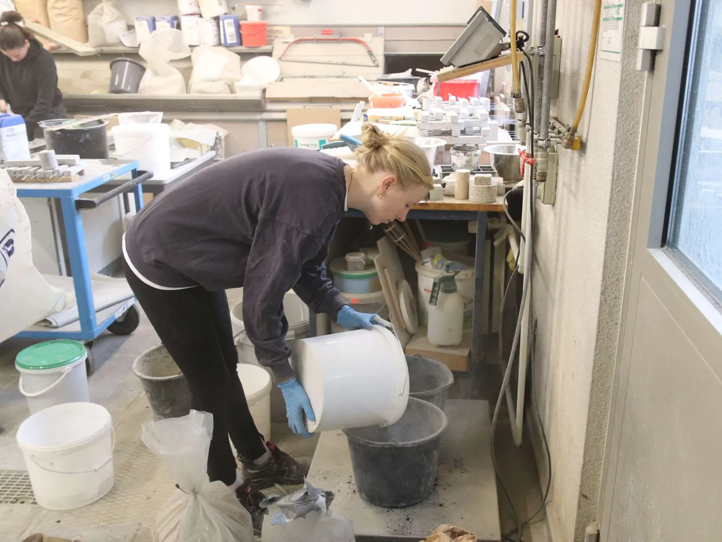 Studentin mischt Beton zur Herstellung von Probekörpern