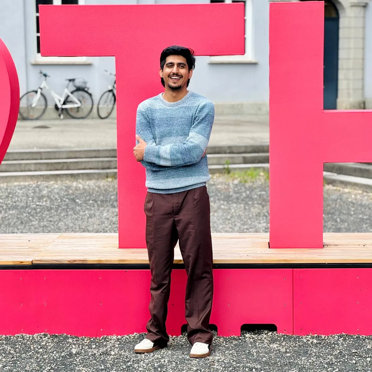 Muhammed Zubair vor dem THA_Logo