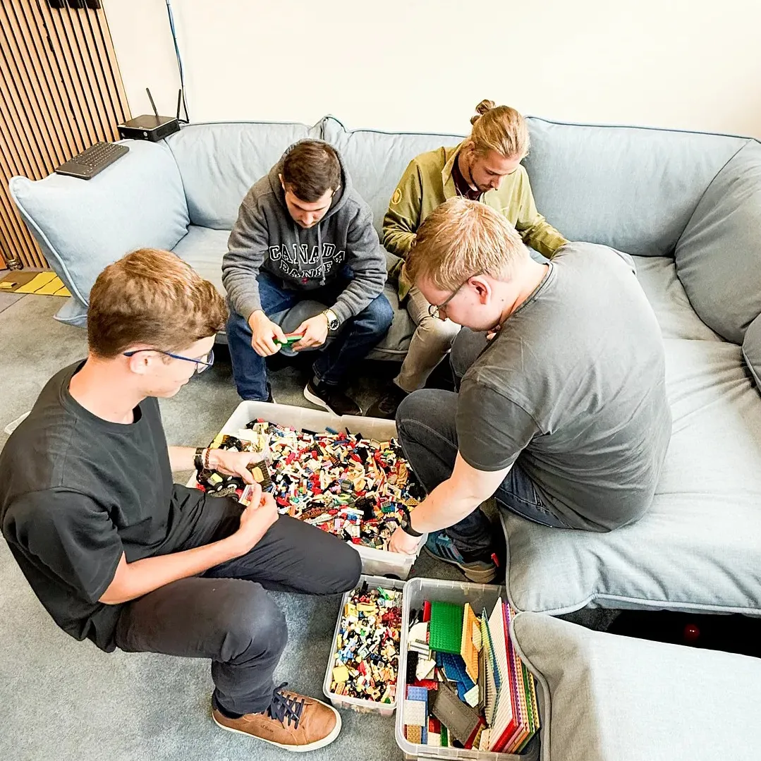Mehrere Studierende vor einer Lego-Kiste