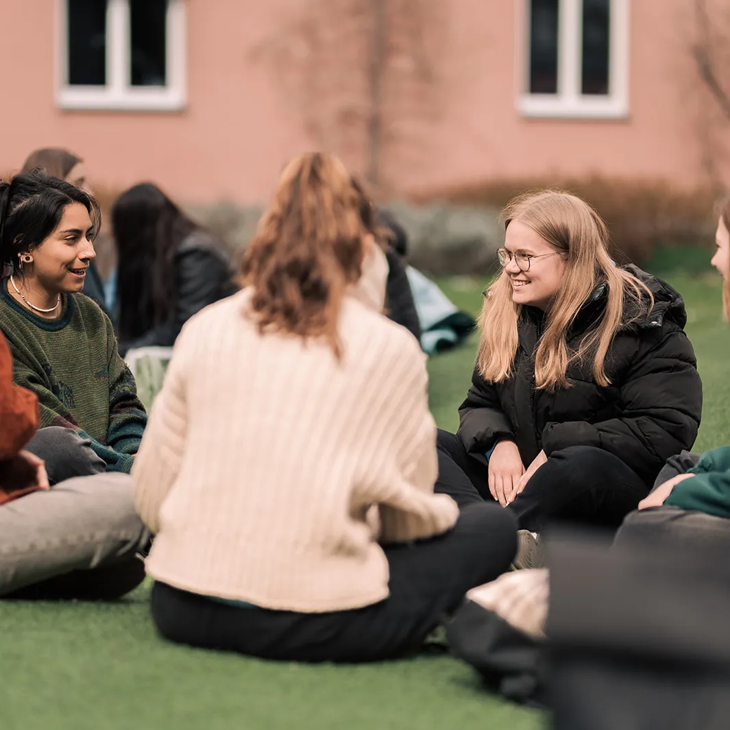 Gruppe Studierender im Gespräch auf Wellenwiese im Innenhof des Campus am Brunnenlech