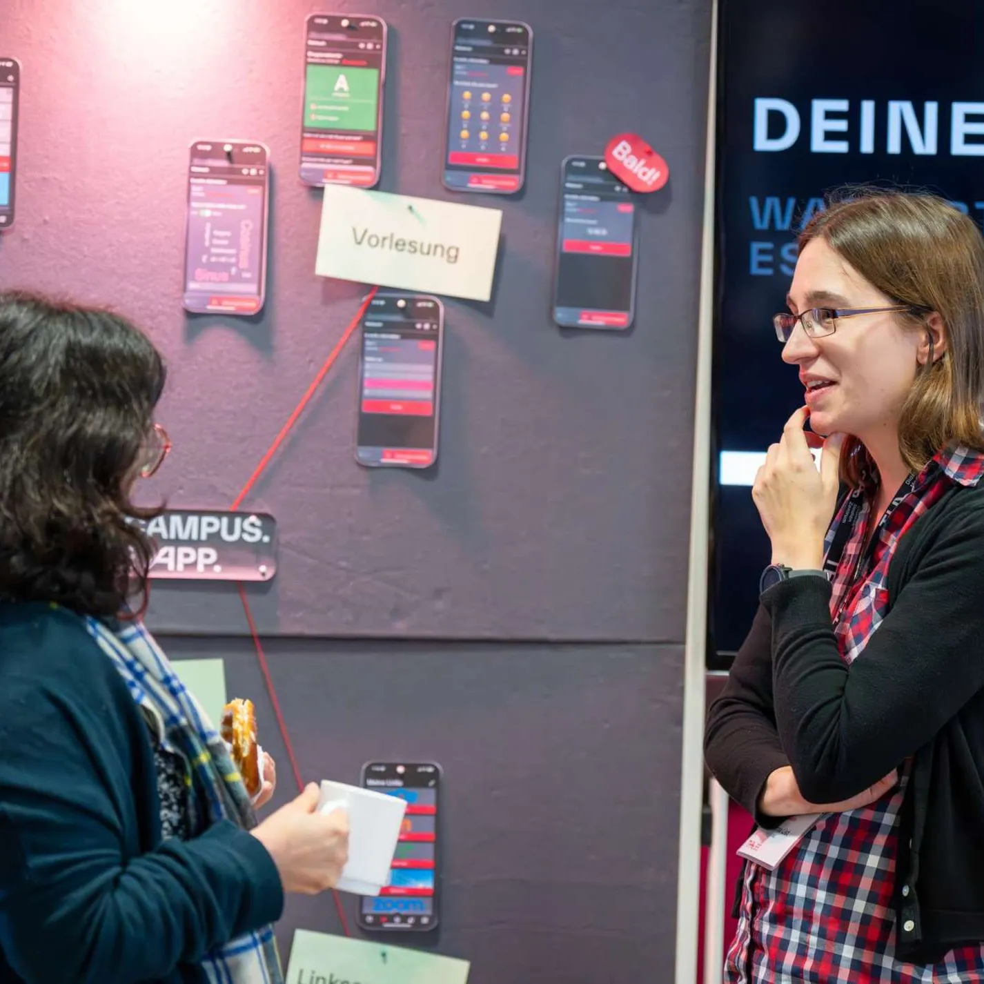 Zwei Personen im Gespräch am App-Stand des DMZ im Foyer