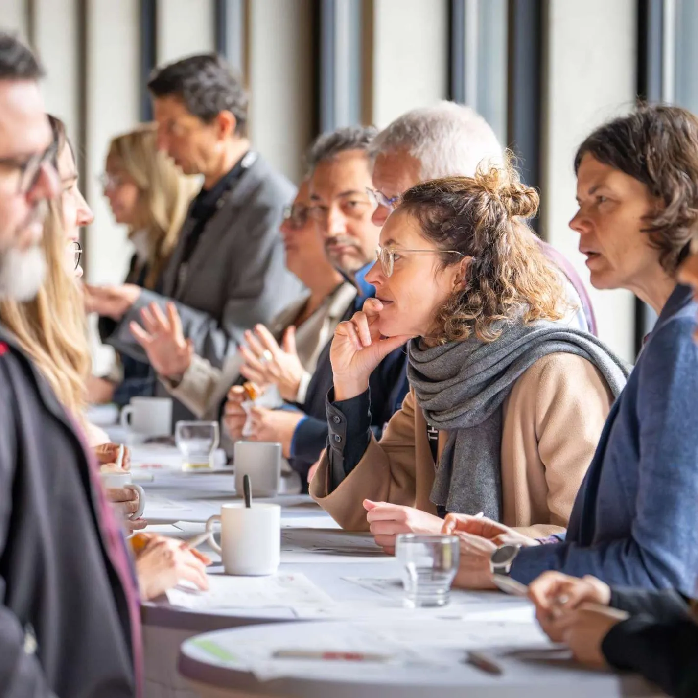 Lehrende im Gespräch an Stehtischen beim Speeddating