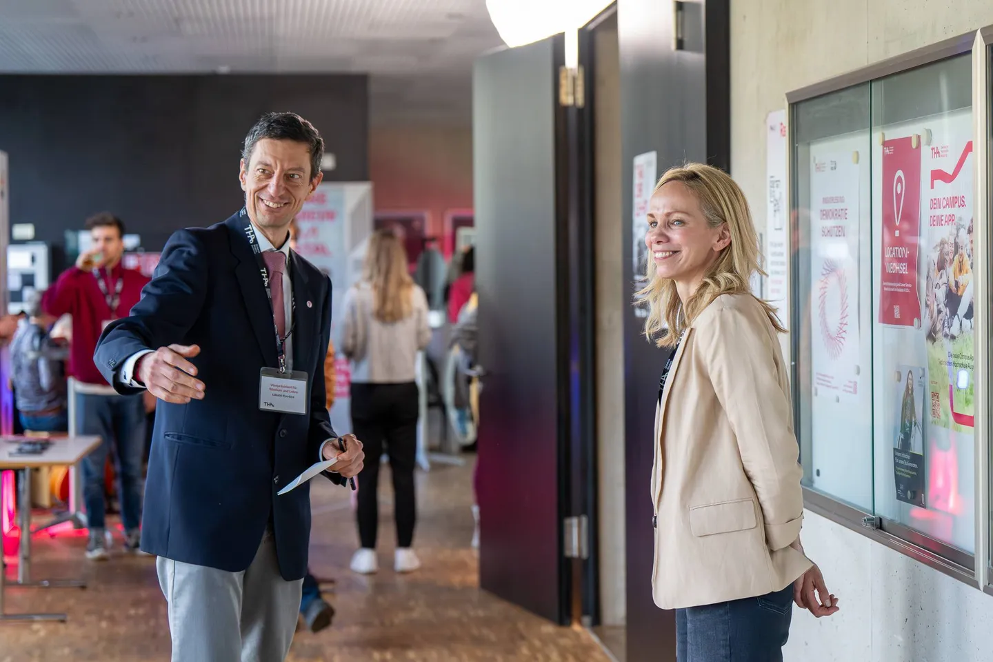 Zwei Teilnehmende unterhalten sich im Foyer