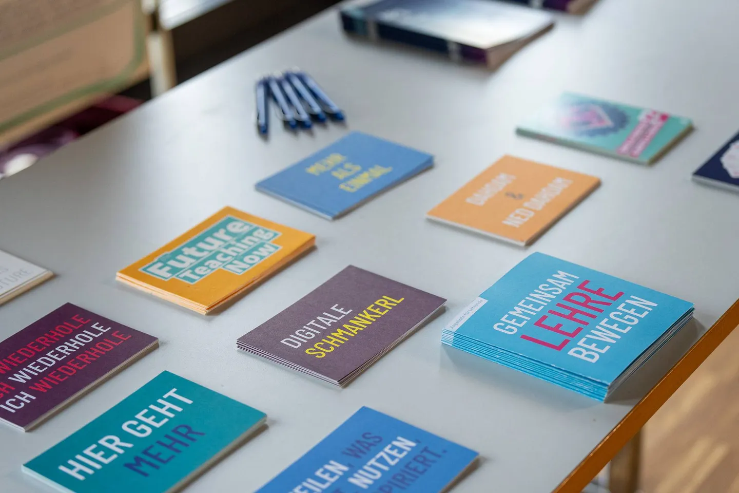 Bunte Postkarten und Informationsmaterial liegen auf einem Tisch