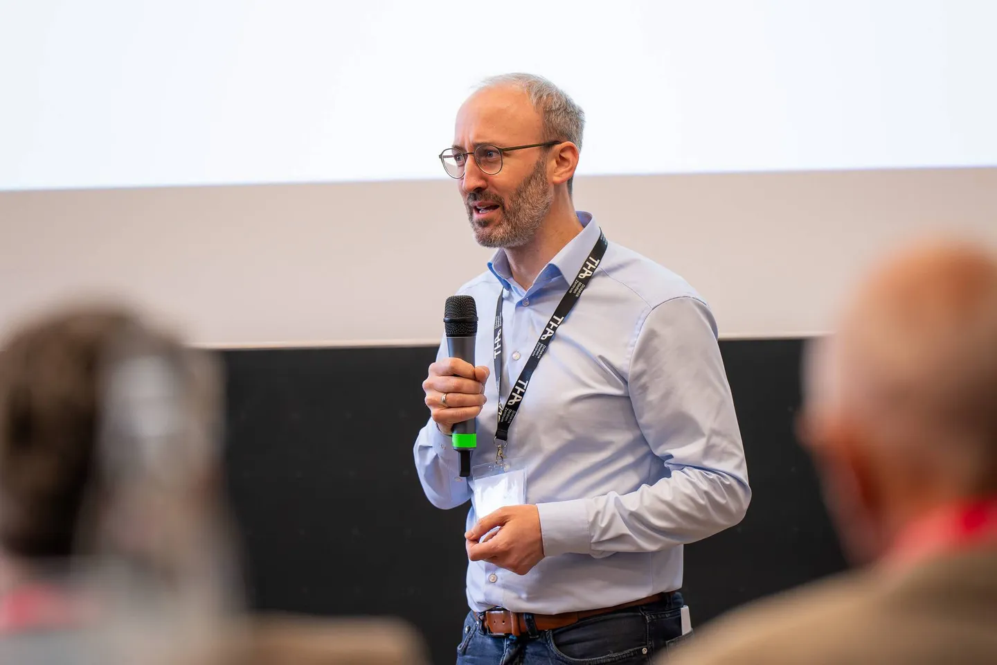 Prof. Dr.-Ing. Dominik Merli spricht mit Mikrofon im Hörsaal