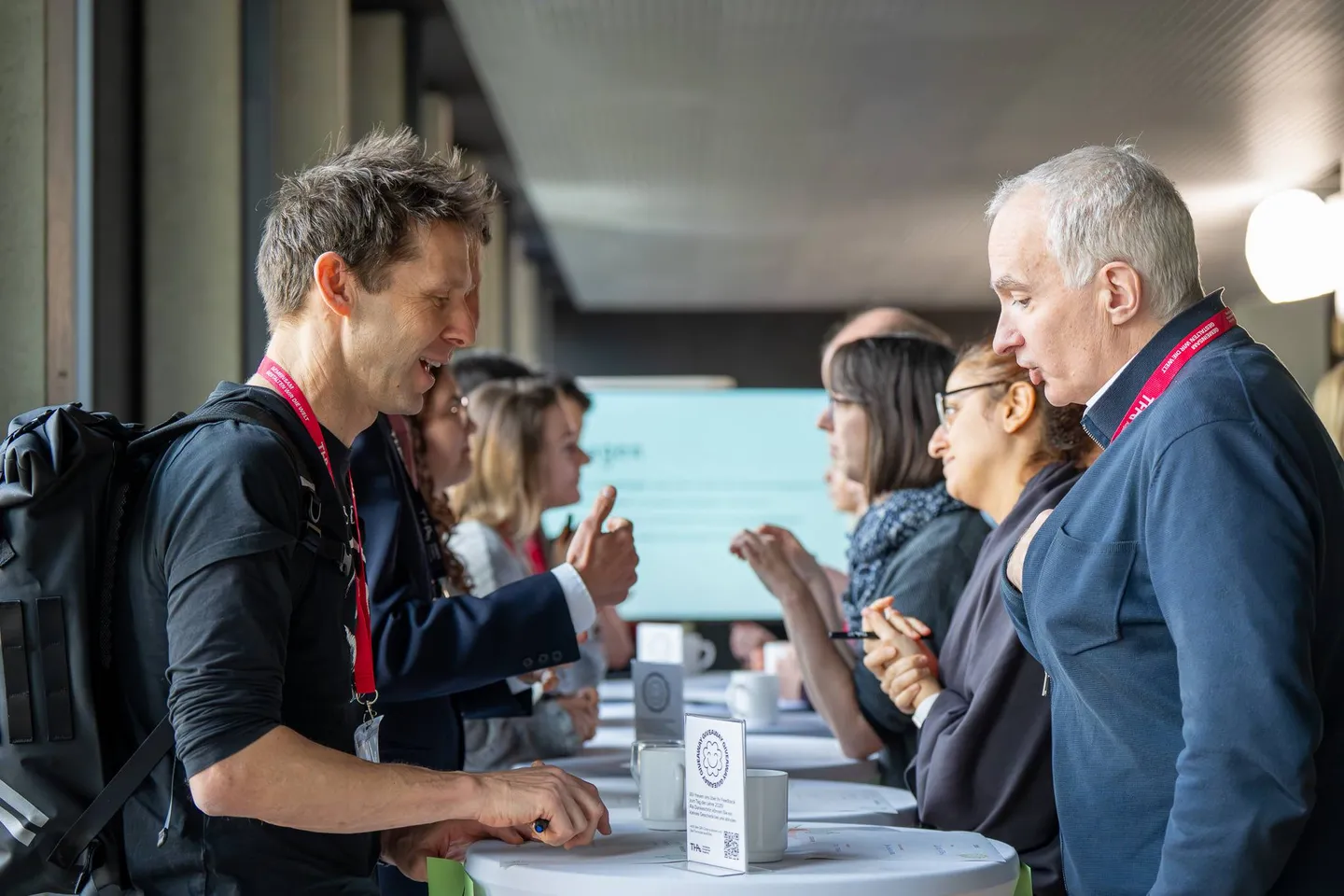 Lehrende sitzen sich beim Speeddating in Zweierreihen gegenüber