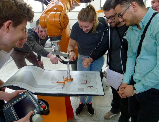 Studierende an einem Roboter Studierende an einem Roboter
