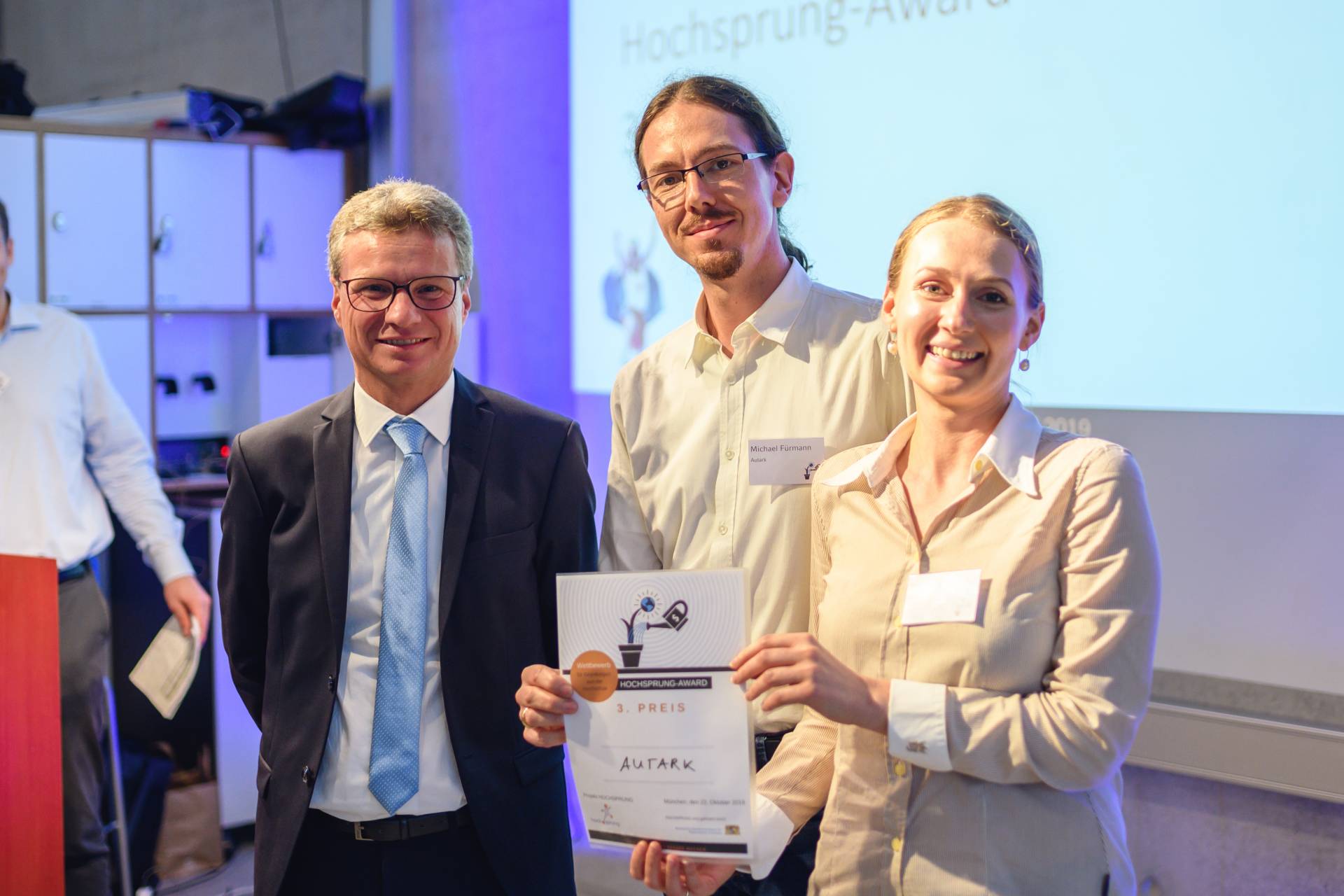 Staatsminister Bernd Sibler (links) überreichte Michael und Margarita Fürmann von der Hochschule Augsburg die Auszeichnung für den dritten Platz beim Hochsprung-Award 2019. Foto: Fabian Stoffers/Hochsprung Staatsminister Bernd Sibler (links) überreichte Michael und Margarita Fürmann von der Hochschule Augsburg die Auszeichnung für den dritten Platz beim Hochsprung-Award 2019. Foto: Fabian Stoffers/Hochsprung
