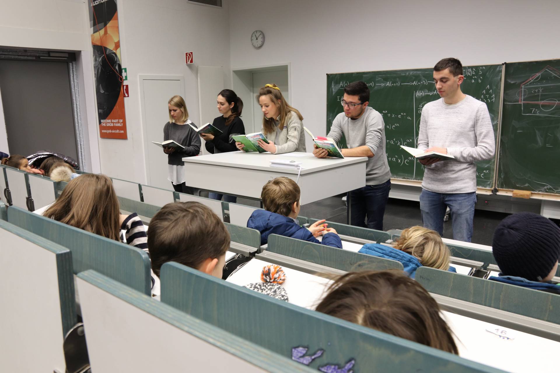 4.-Klässler der Grundschule Augsburg "Vor dem Roten Tor" im Hörsaal der Hochschule Augsburg: Studierende lesen aus "Ronja Räubertochter" im Projekt "Lese-Insel" vor.